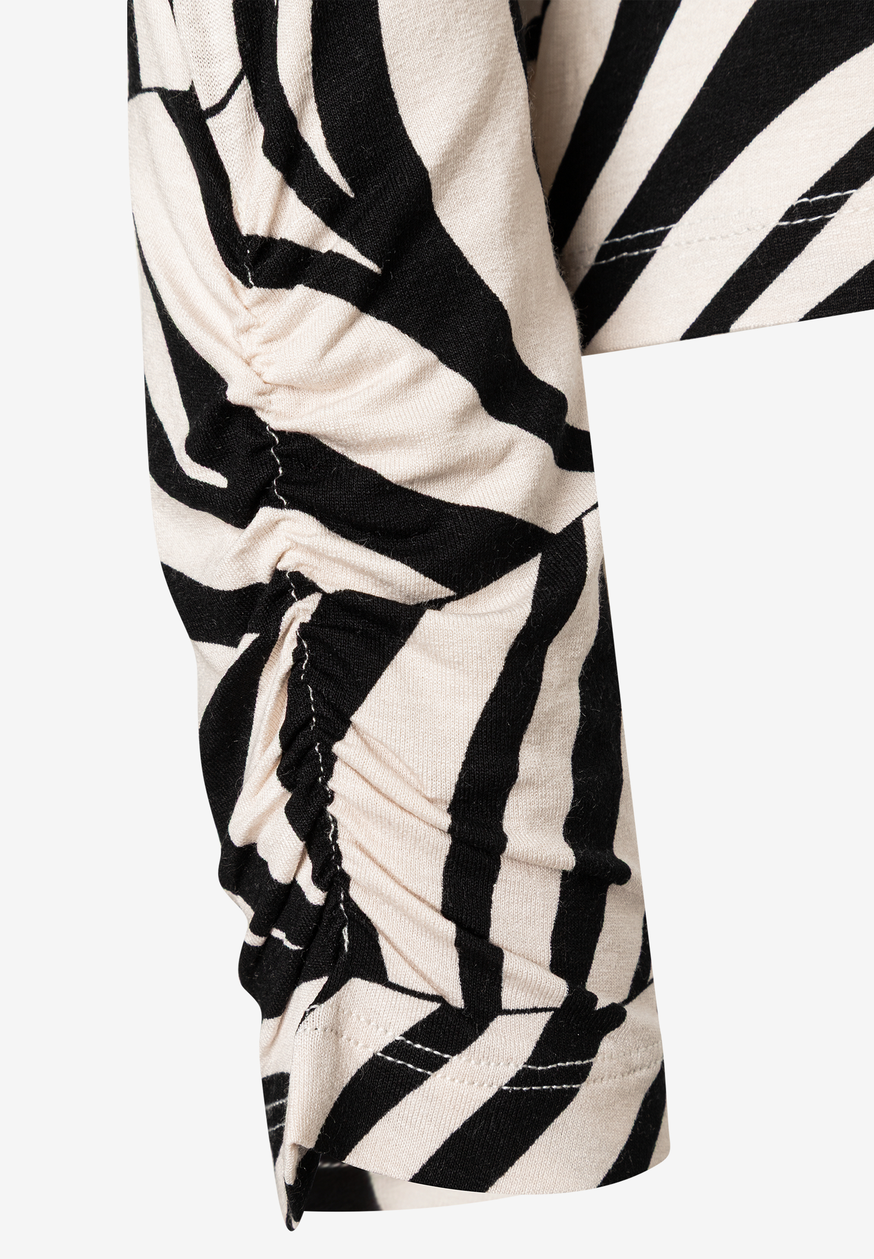 Detailansicht eines MORE & MORE Oberteils mit Zebra-Muster und gerafftem Ärmel aus Jersey. Detailansicht eines MORE & MORE Oberteils mit Zebra-Muster und gerafftem Ärmel aus Jersey.