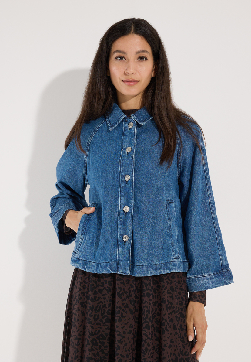 MORE & MORE Jeansjacke aus Denim mit langen Ärmeln und silbernen Knöpfen. Eine Dame trägt die Jacke über einem braun-weiß gemusterten Kleid. MORE & MORE Jeansjacke aus Denim mit langen Ärmeln und silbernen Knöpfen. Eine Dame trägt die Jacke über einem braun-weiß gemusterten Kleid.