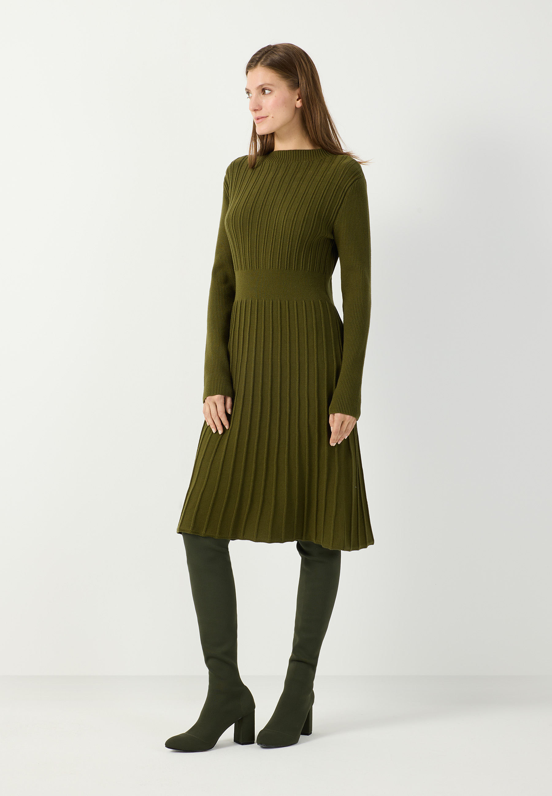 MORE & MORE Rippstrickkleid in Khaki, wadenlang, mit langen Ärmeln und Faltenrock. Model trägt passende Stiefel.