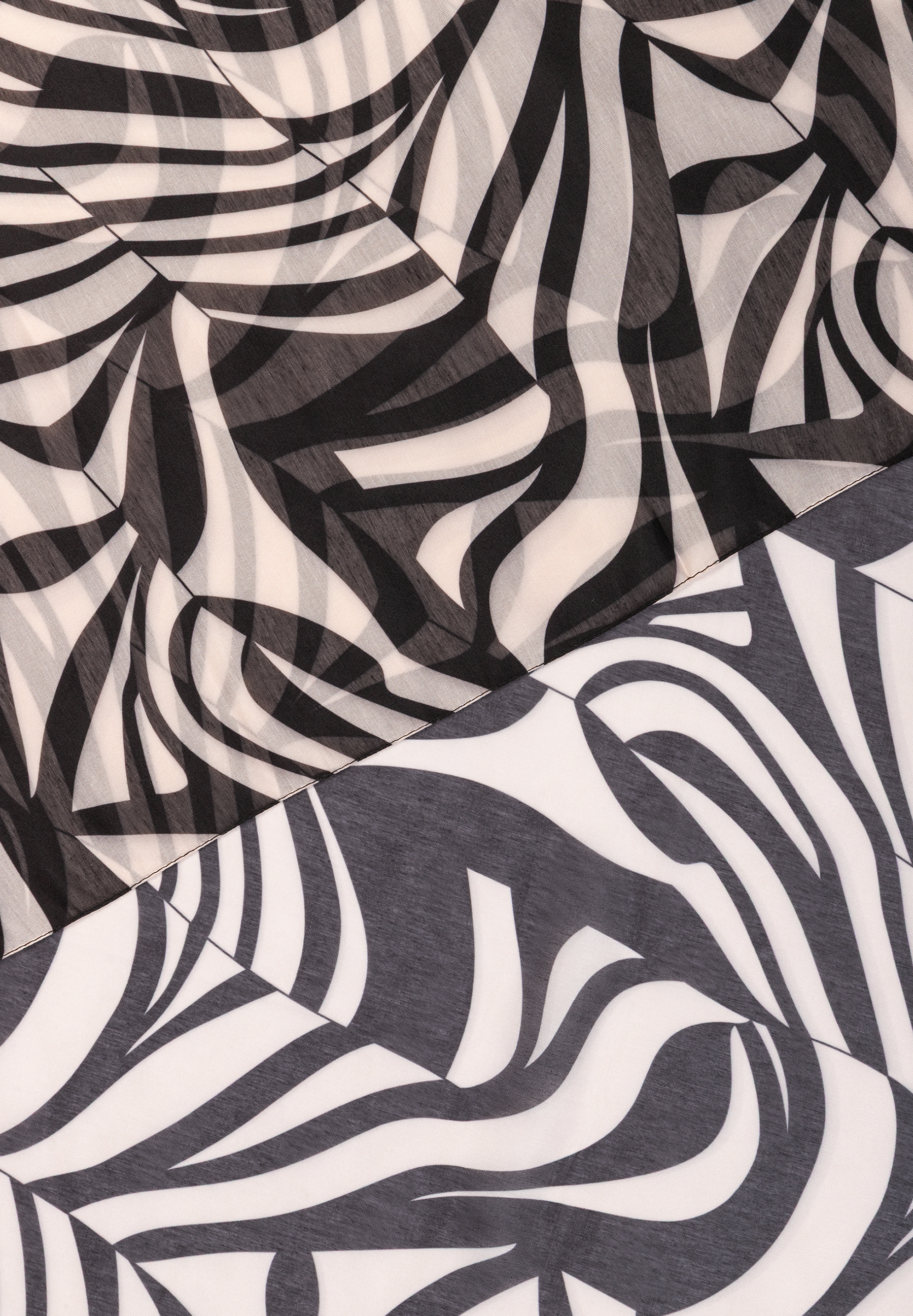 MORE & MORE: Nahaufnahme eines Accessoires mit abstraktem Zebra-Muster in Schwarz und Weiß. MORE & MORE: Nahaufnahme eines Accessoires mit abstraktem Zebra-Muster in Schwarz und Weiß.