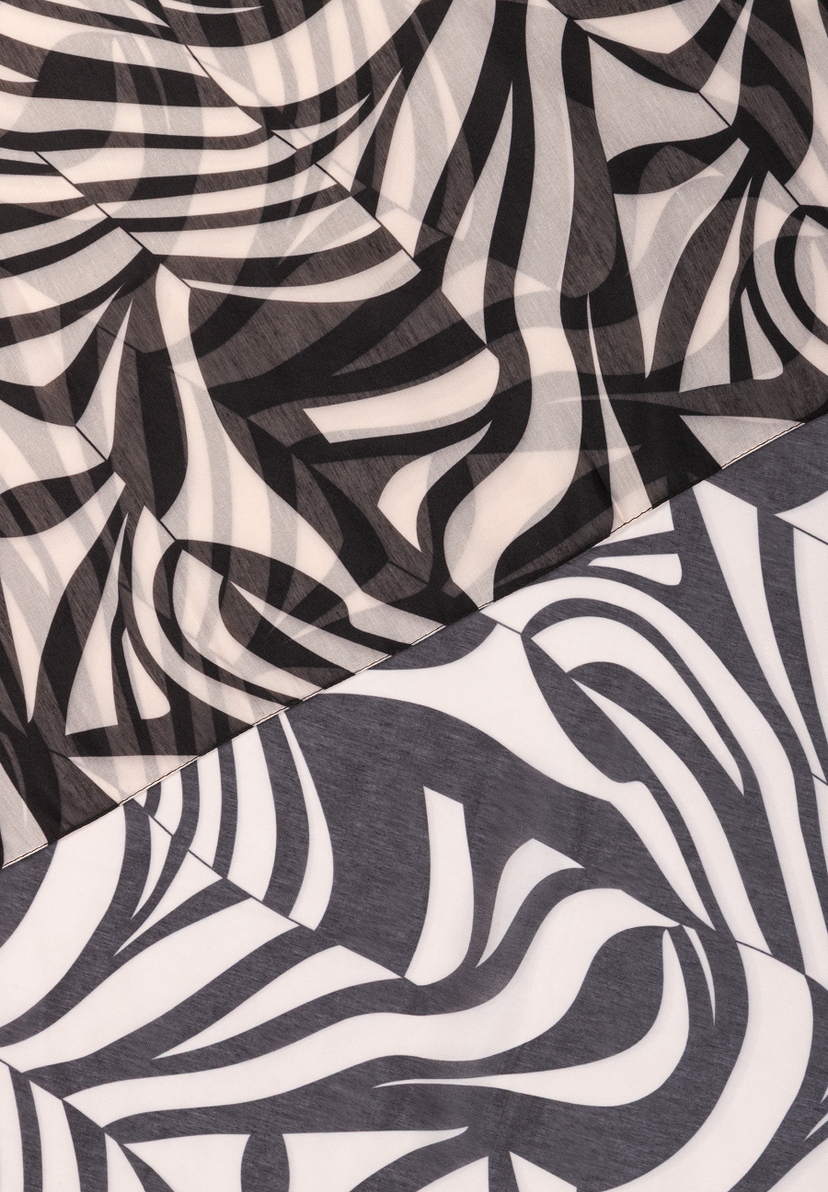 MORE & MORE: Nahaufnahme eines Accessoires mit abstraktem Zebra-Muster in Schwarz und Weiß. MORE & MORE: Nahaufnahme eines Accessoires mit abstraktem Zebra-Muster in Schwarz und Weiß.