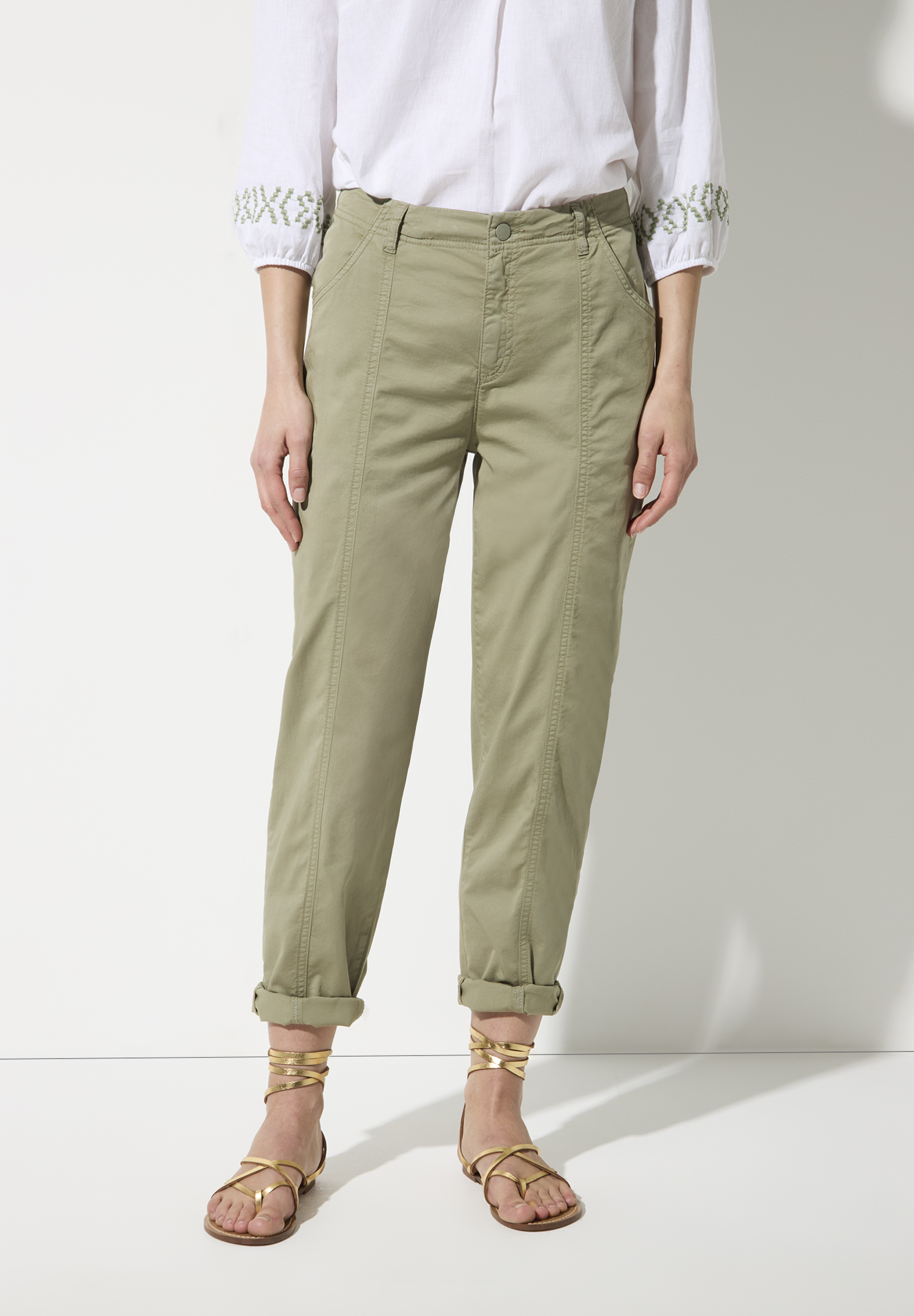 Eine Person trägt eine MORE & MORE Hose aus Baumwollmischung mit Twill- und Stretch-Material und Sandalen.