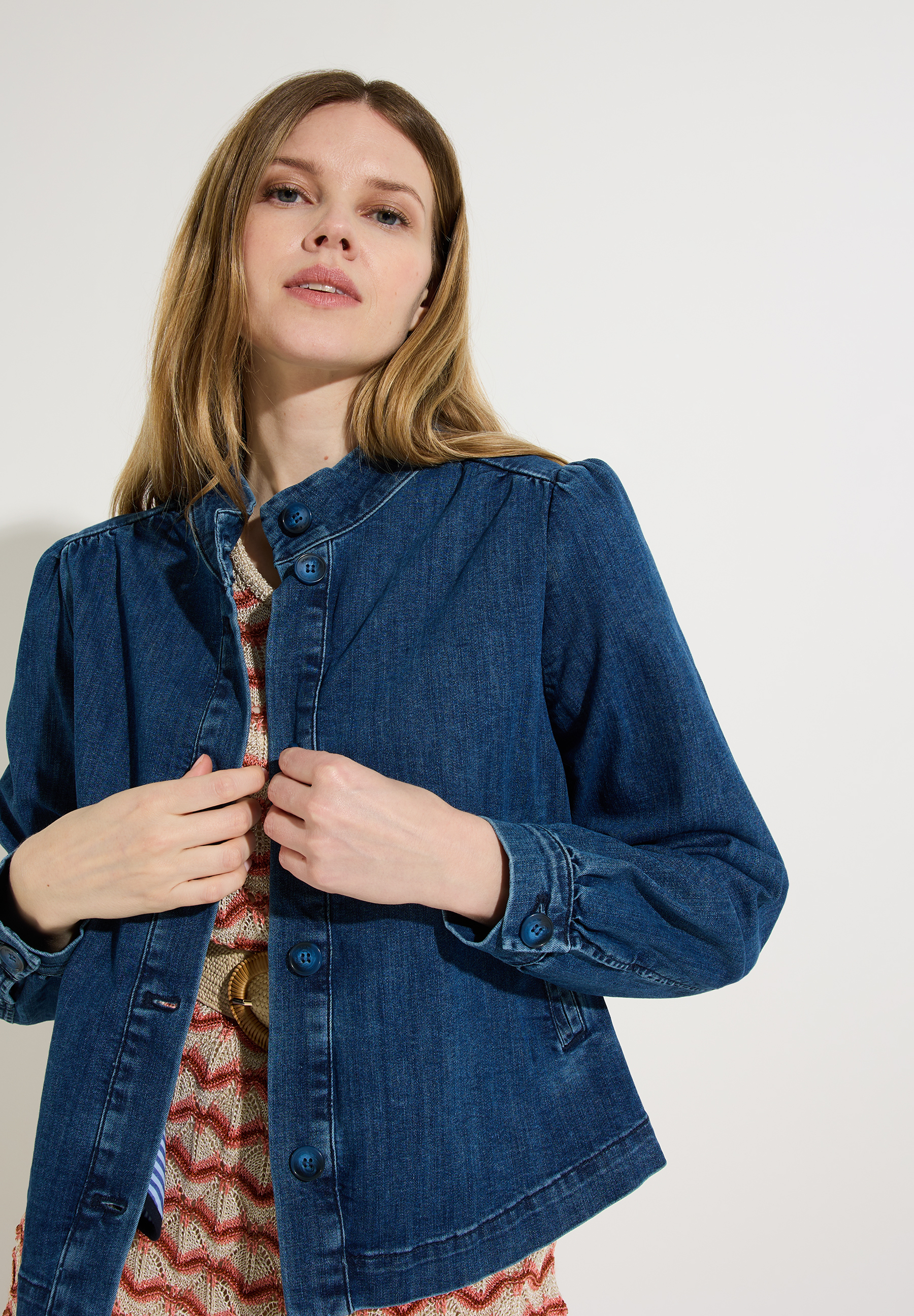 Eine Frau mit MORE & MORE Jeansjacke aus Denim mit Knöpfen und Kragen. Eine Frau mit MORE & MORE Jeansjacke aus Denim mit Knöpfen und Kragen.