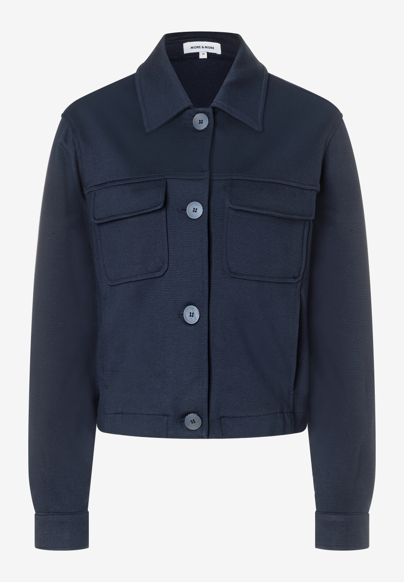 Eine marineblaue Jersey-Bluse von MORE & MORE mit Knöpfen und Brusttaschen. Eine marineblaue Jersey-Bluse von MORE & MORE mit Knöpfen und Brusttaschen.