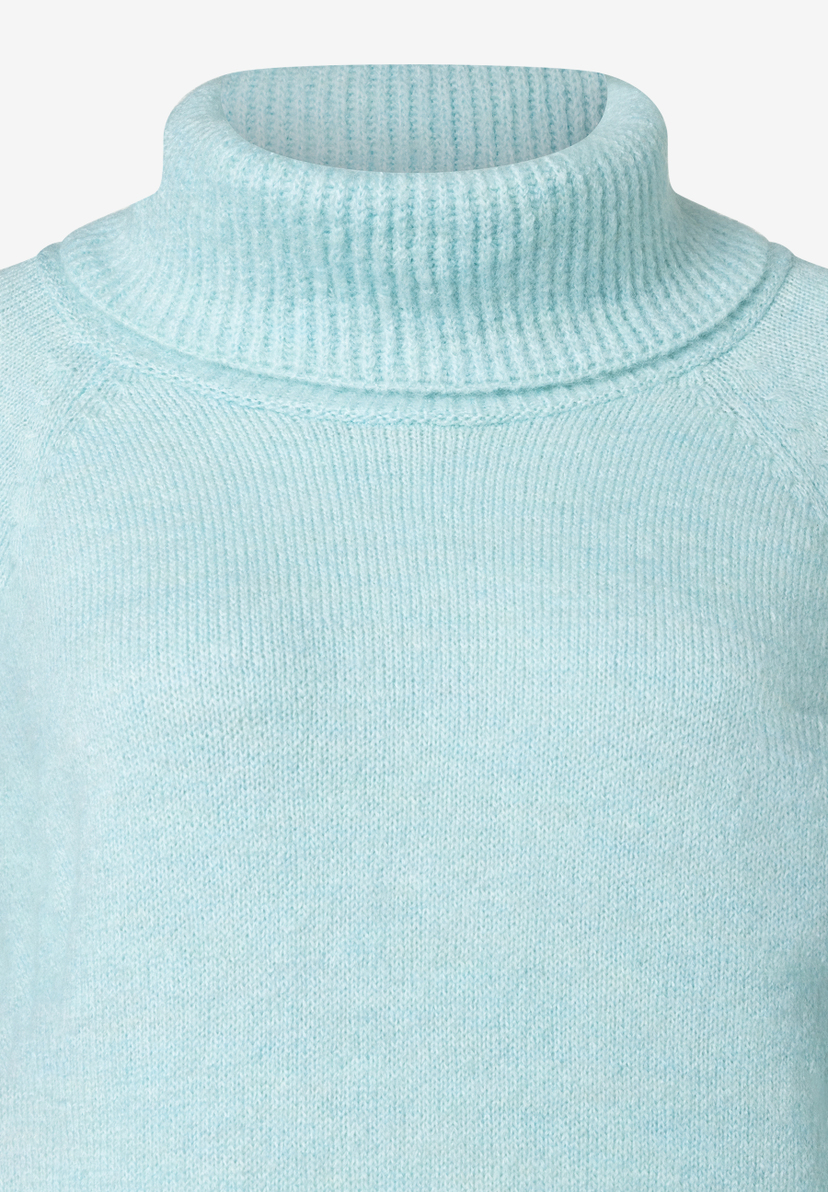 Nahaufnahme eines hellblauen MORE & MORE Strickpullovers mit Rollkragen. Nahaufnahme eines hellblauen MORE & MORE Strickpullovers mit Rollkragen.