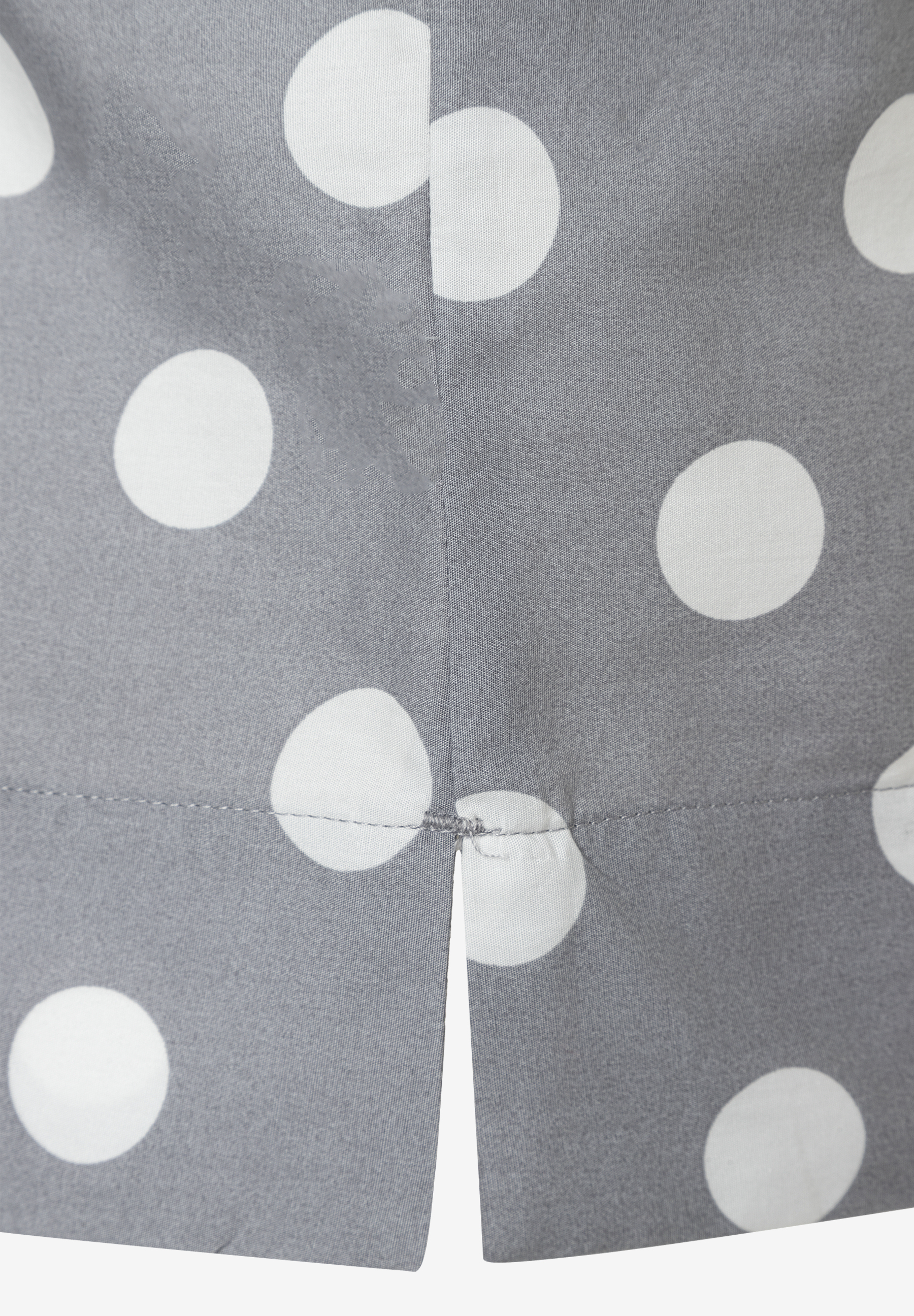 Detailansicht einer grauen MORE & MORE Bluse mit weißen Punkten und einem kleinen Schlitz am Saum. Detailansicht einer grauen MORE & MORE Bluse mit weißen Punkten und einem kleinen Schlitz am Saum.