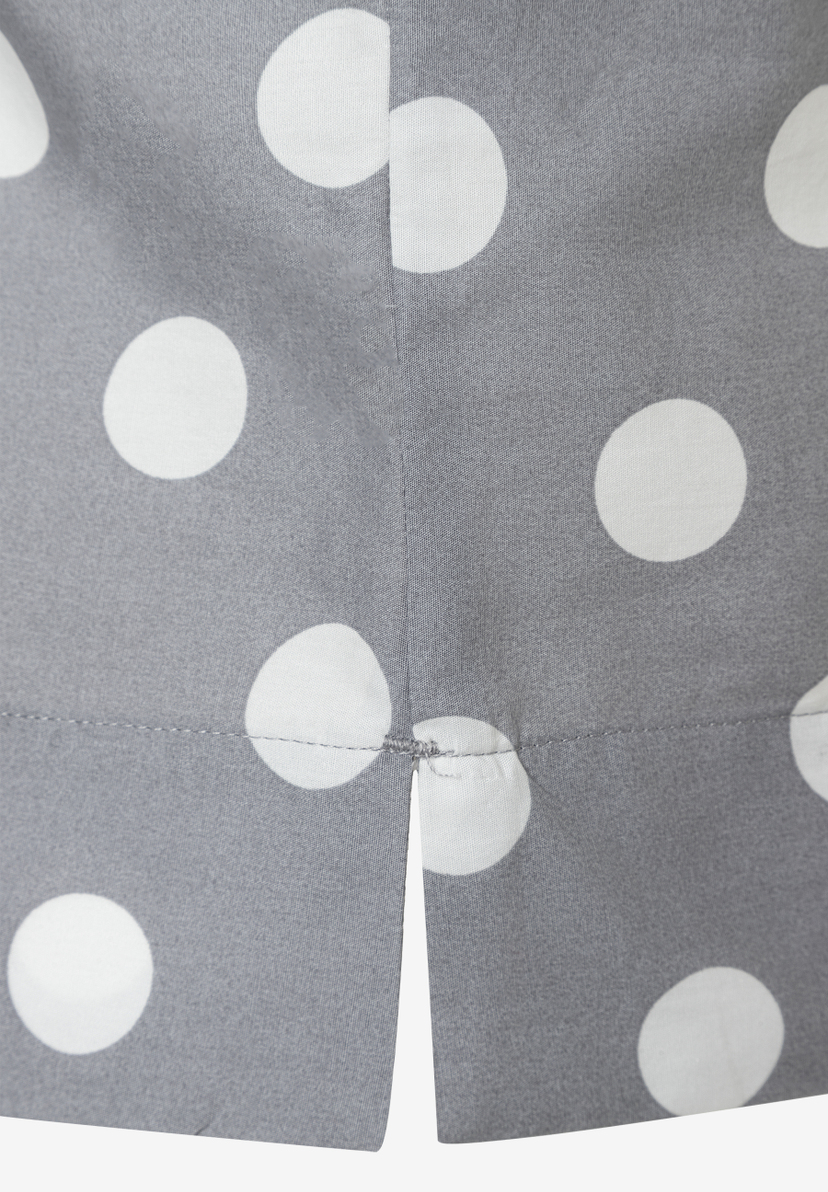 Detailansicht einer grauen MORE & MORE Bluse mit weißen Punkten und einem kleinen Schlitz am Saum. Detailansicht einer grauen MORE & MORE Bluse mit weißen Punkten und einem kleinen Schlitz am Saum.