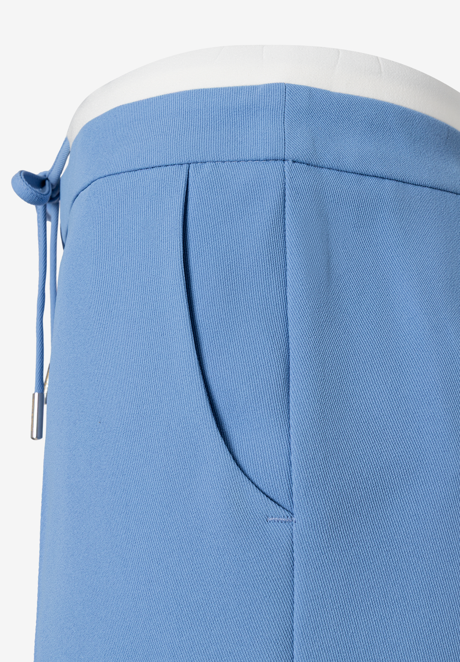Detailaufnahme einer hellblauen MORE & MORE Hose mit Tasche und Kordelzug. Detailaufnahme einer hellblauen MORE & MORE Hose mit Tasche und Kordelzug.