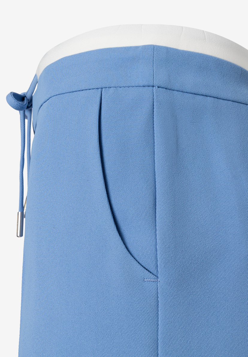 Detailaufnahme einer hellblauen MORE & MORE Hose mit Tasche und Kordelzug. Detailaufnahme einer hellblauen MORE & MORE Hose mit Tasche und Kordelzug.