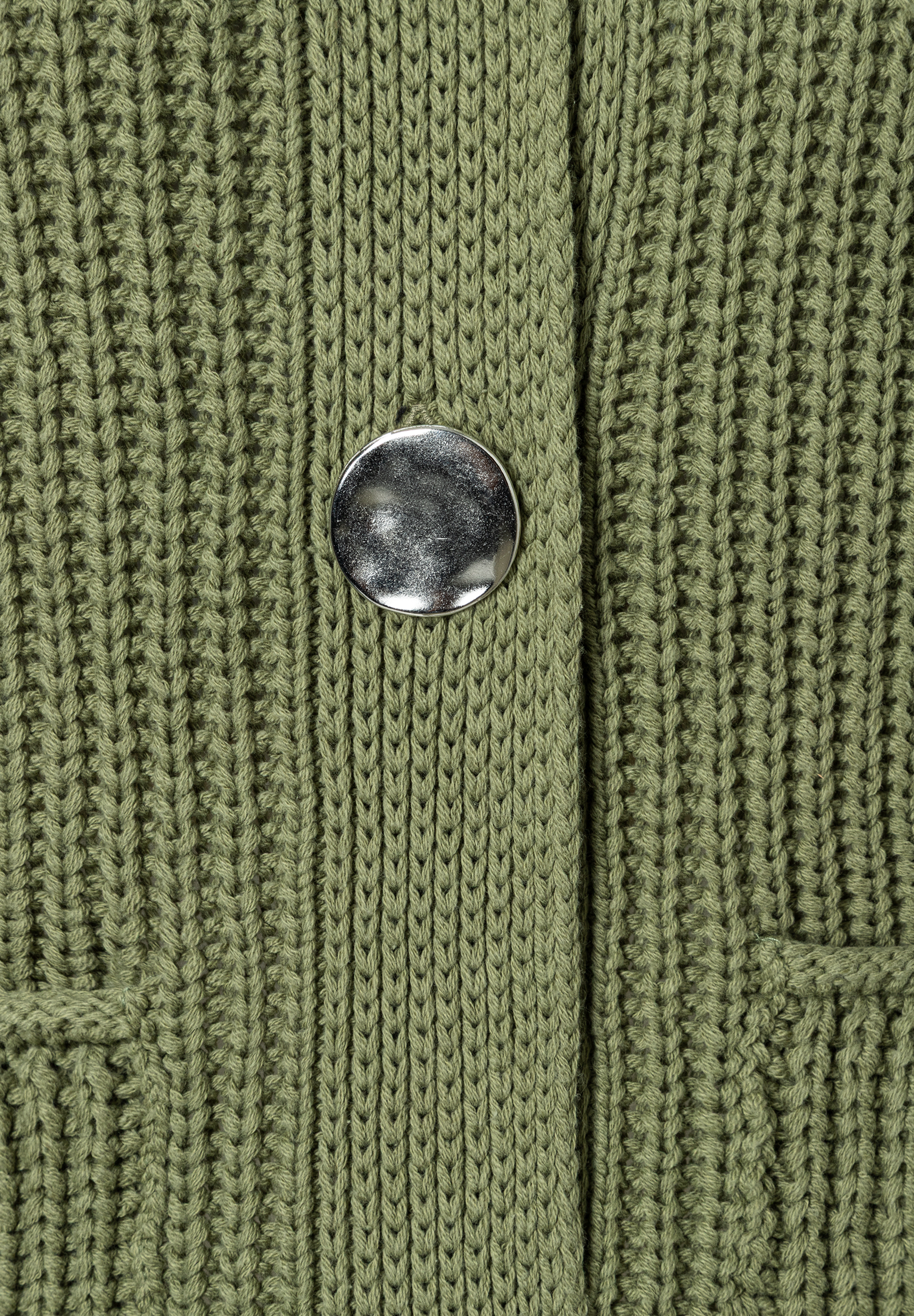 Nahaufnahme einer grünen MORE & MORE Strickjacke mit silberfarbenem Knopf und Rippstrick-Muster. Nahaufnahme einer grünen MORE & MORE Strickjacke mit silberfarbenem Knopf und Rippstrick-Muster.