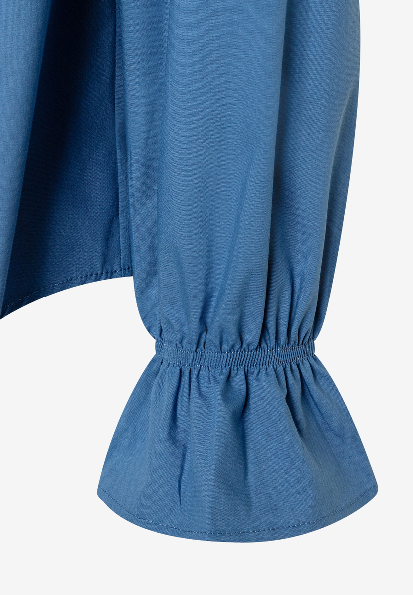 Detailaufnahme eines MORE & MORE Oberteils aus blauer Popeline-Baumwollmischung mit elastischen Ärmelbündchen. Detailaufnahme eines MORE & MORE Oberteils aus blauer Popeline-Baumwollmischung mit elastischen Ärmelbündchen.