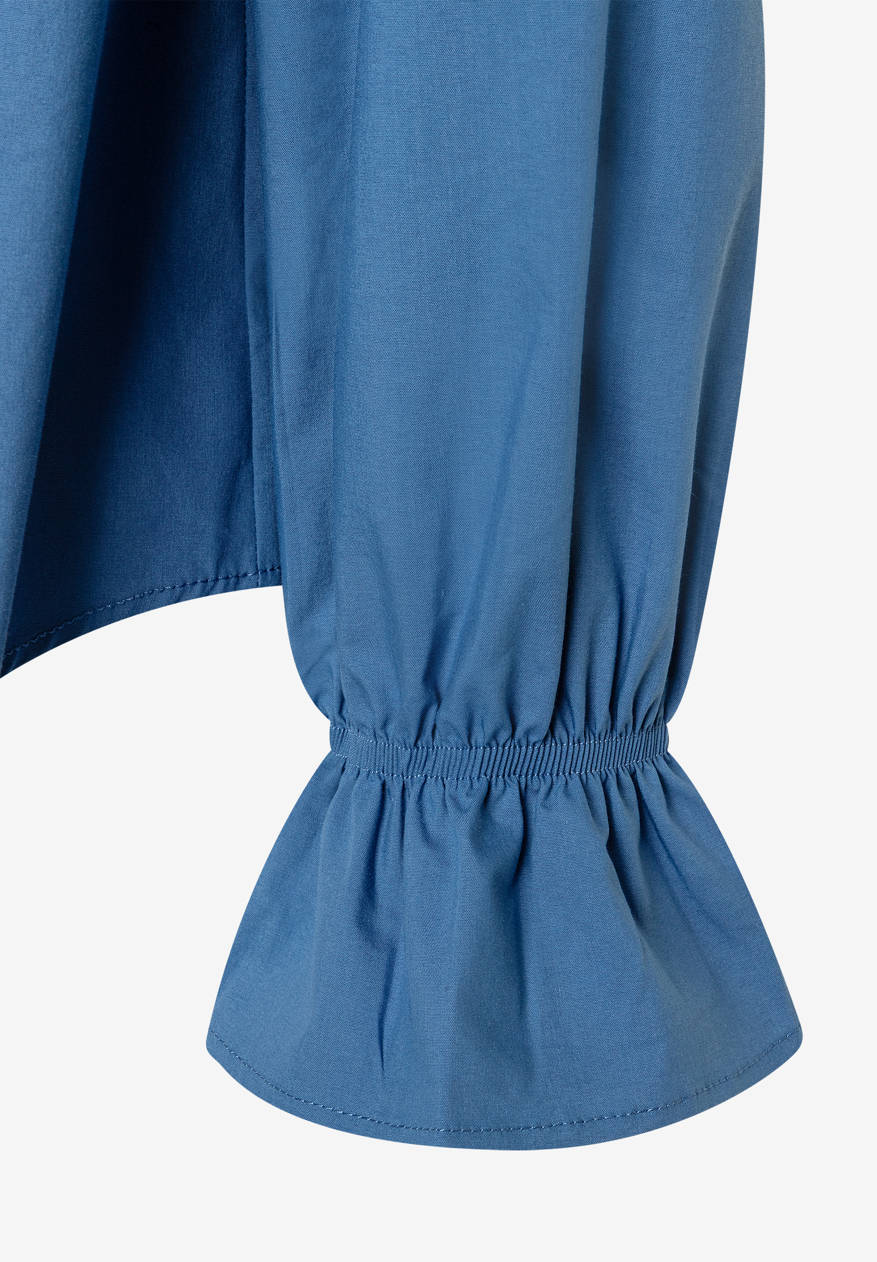 Detailaufnahme eines MORE & MORE Oberteils aus blauer Popeline-Baumwollmischung mit elastischen Ärmelbündchen. Detailaufnahme eines MORE & MORE Oberteils aus blauer Popeline-Baumwollmischung mit elastischen Ärmelbündchen.