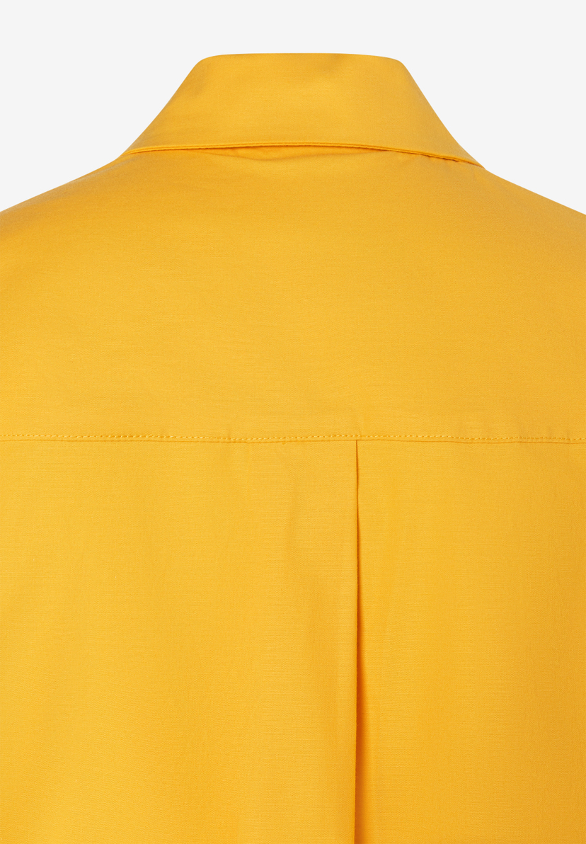 Nahaufnahme der Rückseite einer gelben MORE & MORE Bluse aus Popeline mit Kragen und Falte. Nahaufnahme der Rückseite einer gelben MORE & MORE Bluse aus Popeline mit Kragen und Falte.