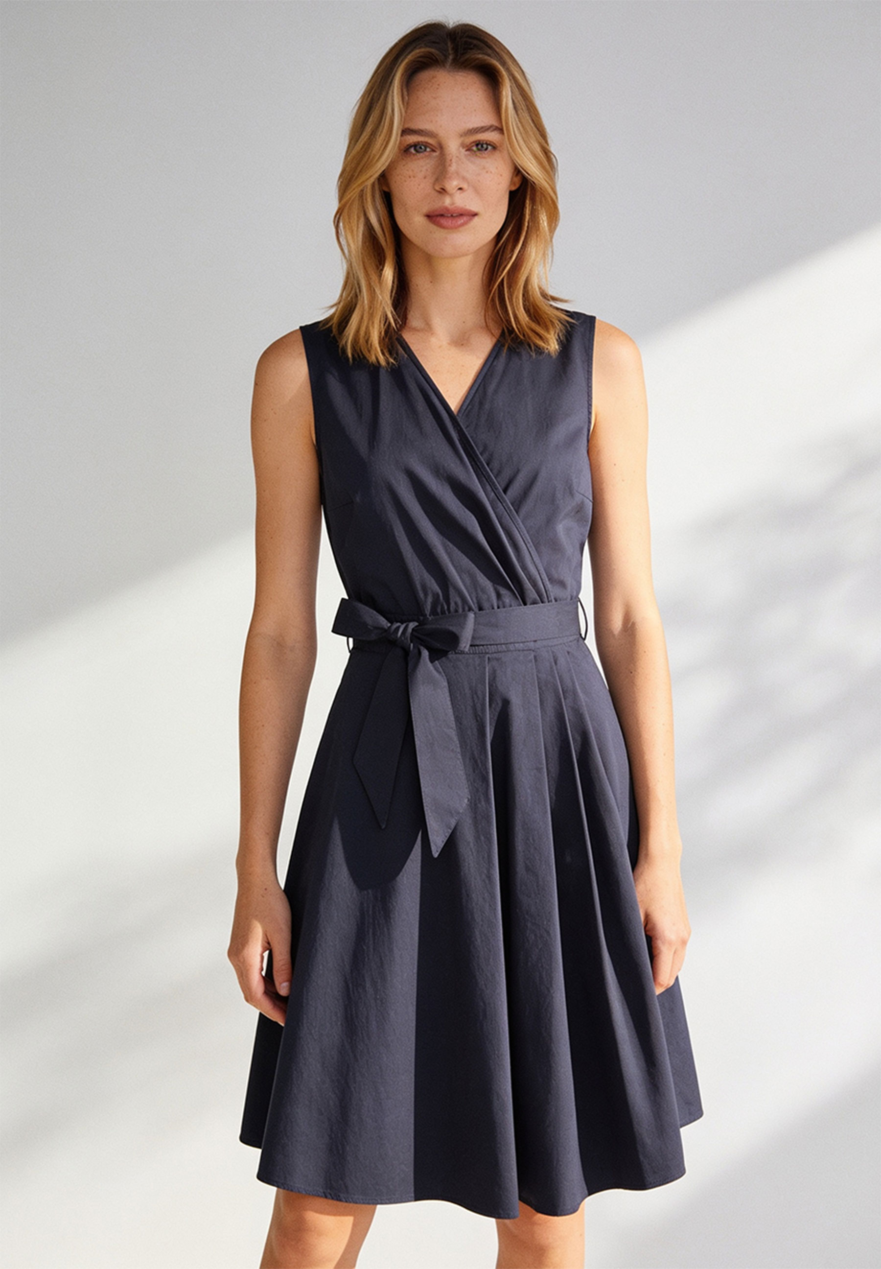 AI generated - MORE & MORE Damen-Kleid aus elastischer Popeline. Das ärmellose schwarze Wickelkleid mit V-Ausschnitt ist knielang.