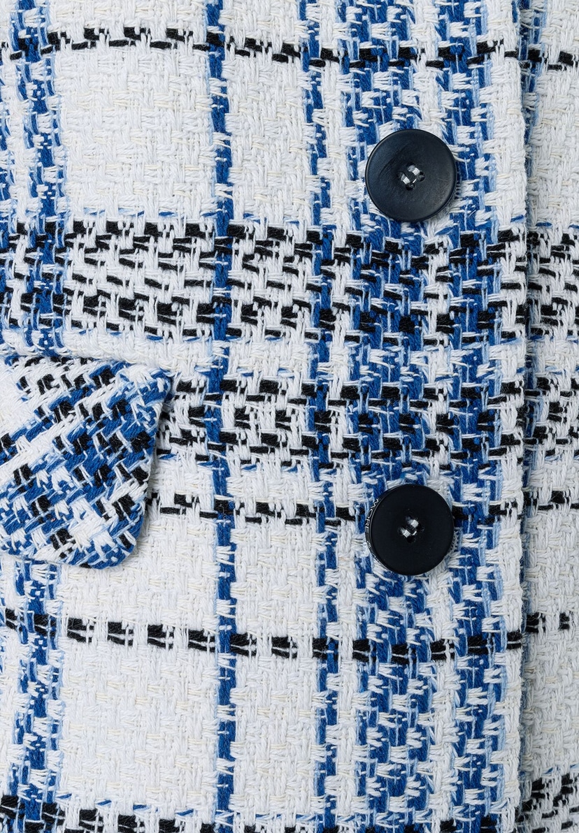 Detailansicht eines MORE & MORE Bouclé-Blazers mit blau-schwarz-weißem Karomuster und dunklen Knöpfen. Detailansicht eines MORE & MORE Bouclé-Blazers mit blau-schwarz-weißem Karomuster und dunklen Knöpfen.