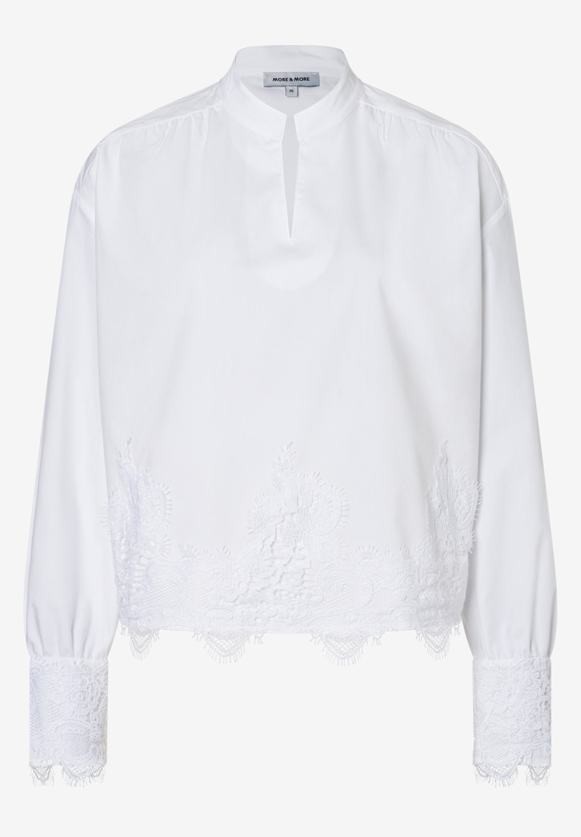 Eine weiße Bluse von MORE & MORE mit langen Ärmeln und einem Spitzenbesatz. Eine weiße Bluse von MORE & MORE mit langen Ärmeln und einem Spitzenbesatz.