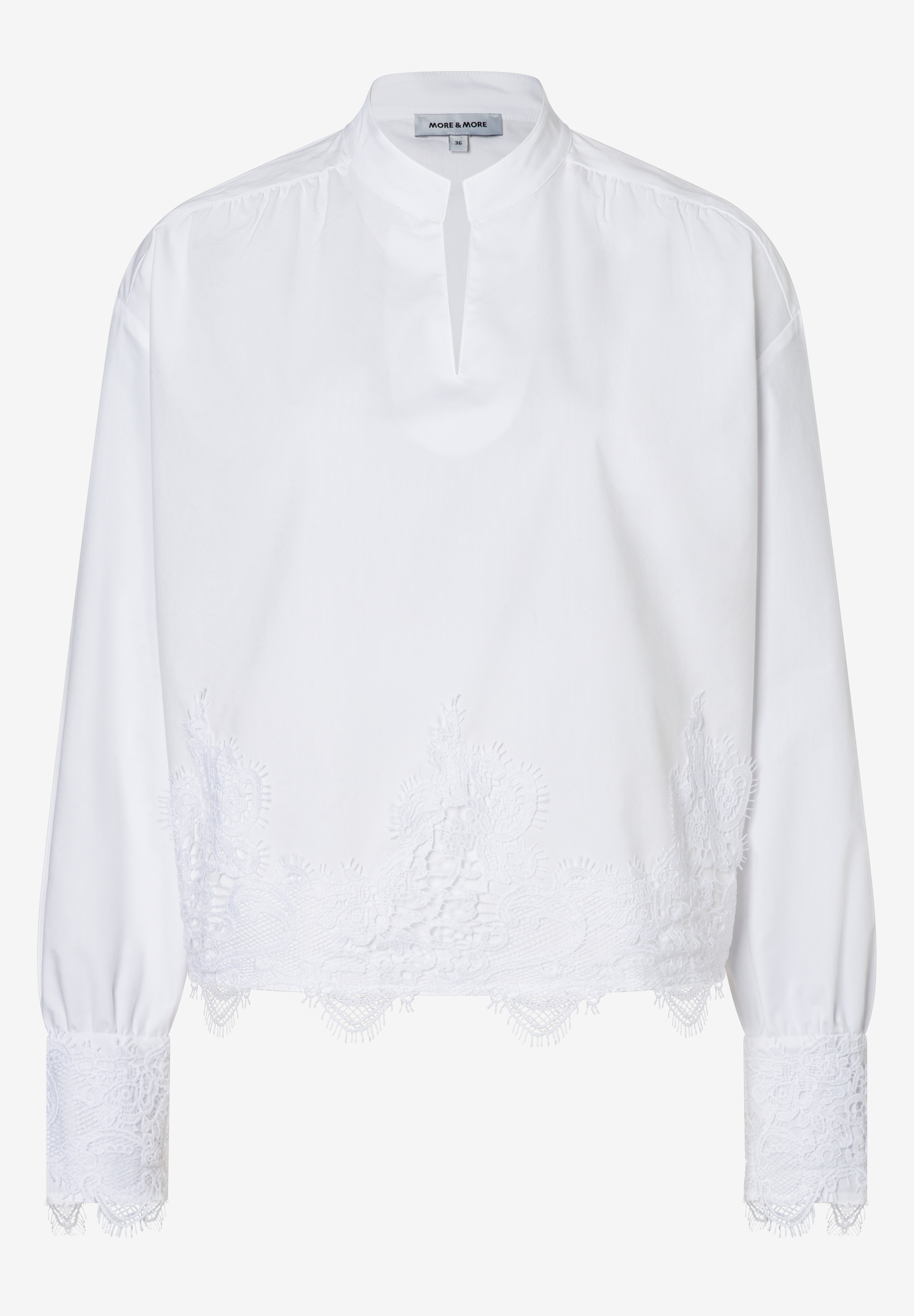 Eine weiße Bluse von MORE & MORE mit langen Ärmeln und einem Spitzenbesatz. Eine weiße Bluse von MORE & MORE mit langen Ärmeln und einem Spitzenbesatz.