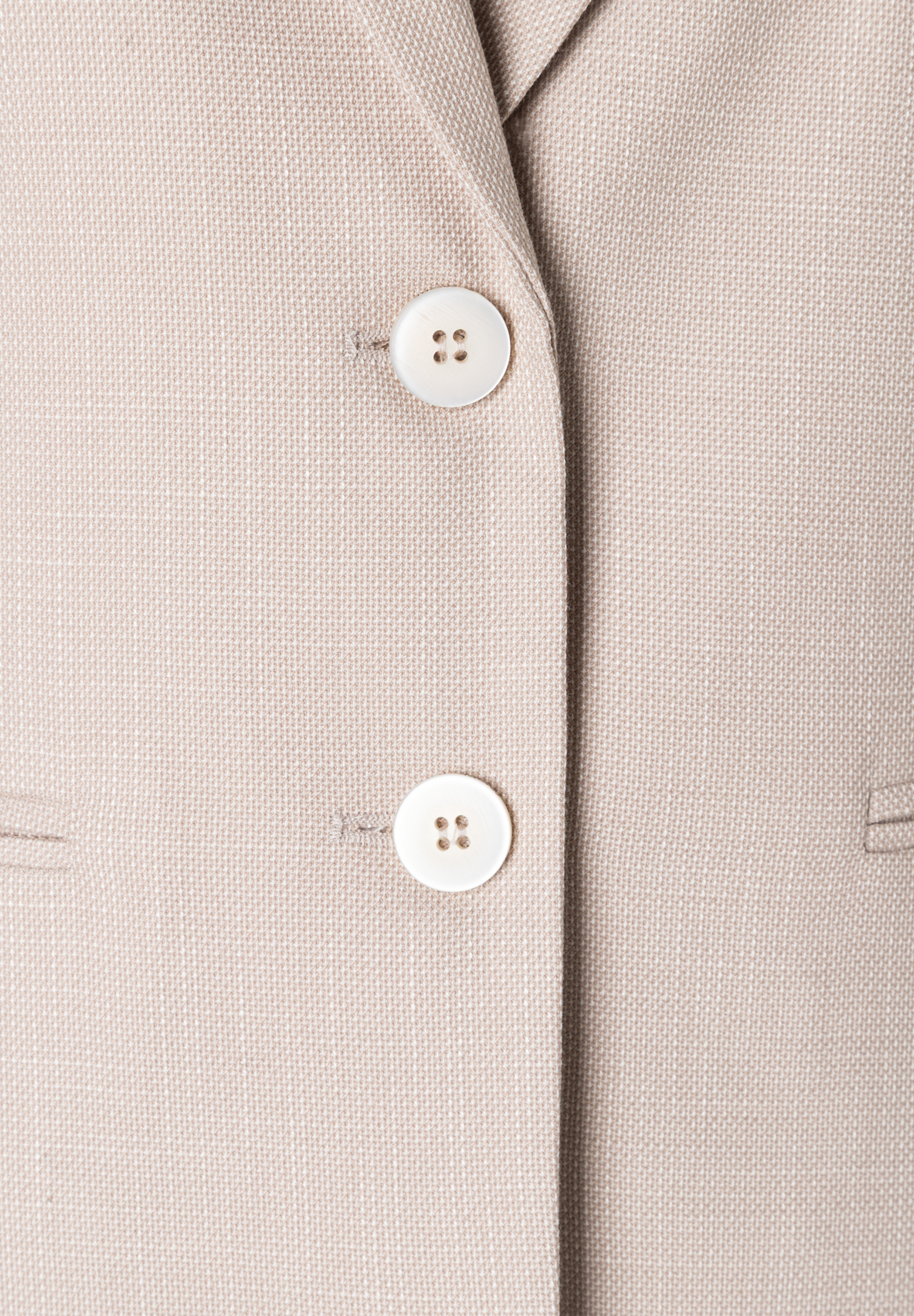 Nahaufnahme eines MORE & MORE Blazers mit zwei Knöpfen und Webware-Struktur. Nahaufnahme eines MORE & MORE Blazers mit zwei Knöpfen und Webware-Struktur.