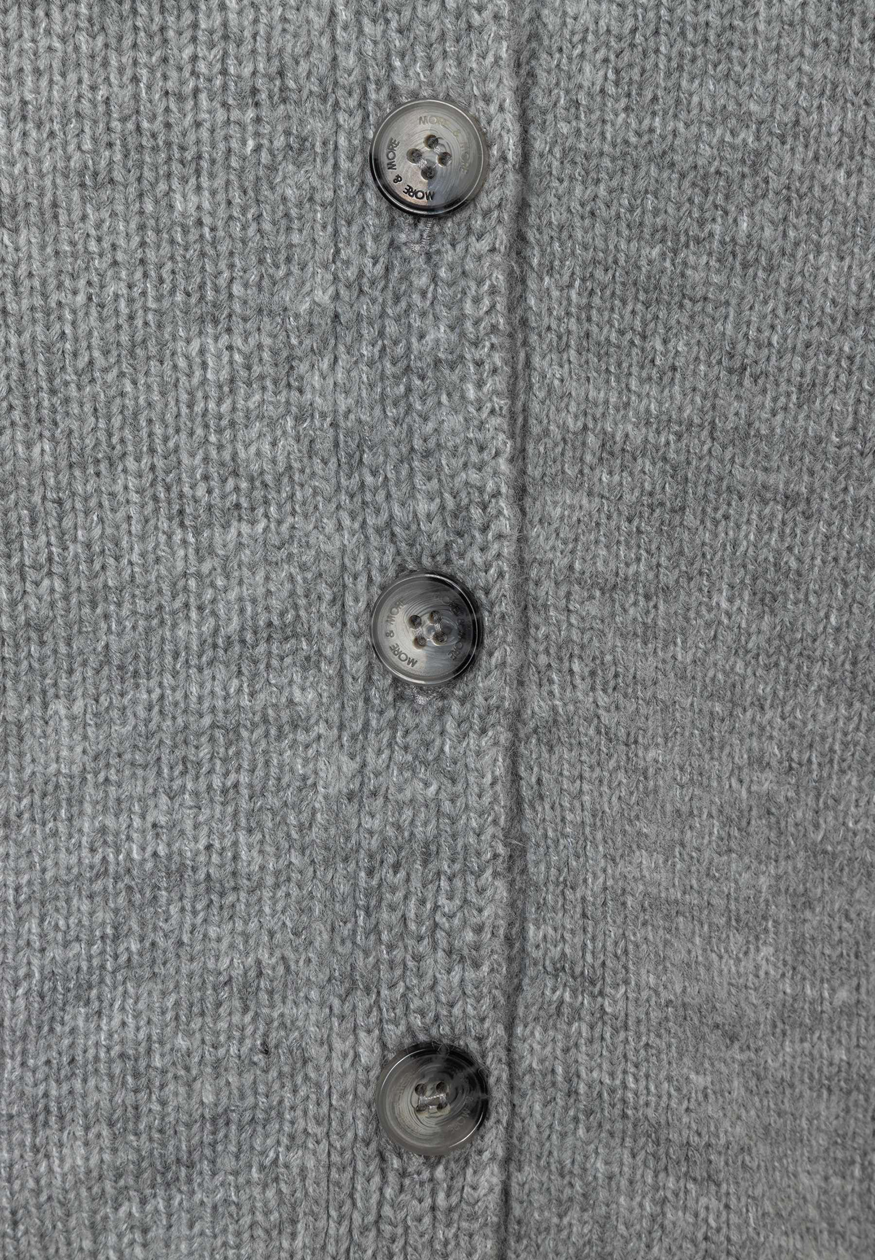 Detailaufnahme eines grauen MORE & MORE Strick-Oberteils mit Knöpfen. Detailaufnahme eines grauen MORE & MORE Strick-Oberteils mit Knöpfen.