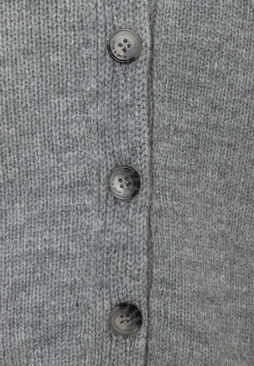 Detailaufnahme eines grauen MORE & MORE Strick-Oberteils mit Knöpfen. Detailaufnahme eines grauen MORE & MORE Strick-Oberteils mit Knöpfen.