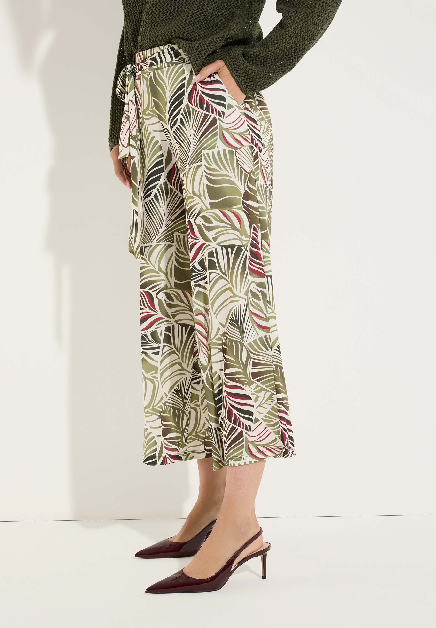 MORE & MORE Jersey-Hose mit Blättermuster in Oliv-Grün und Weinrot. Das Model trägt dazu ein Tanktop und Sandalen. MORE & MORE Jersey-Hose mit Blättermuster in Oliv-Grün und Weinrot. Das Model trägt dazu ein Tanktop und Sandalen.