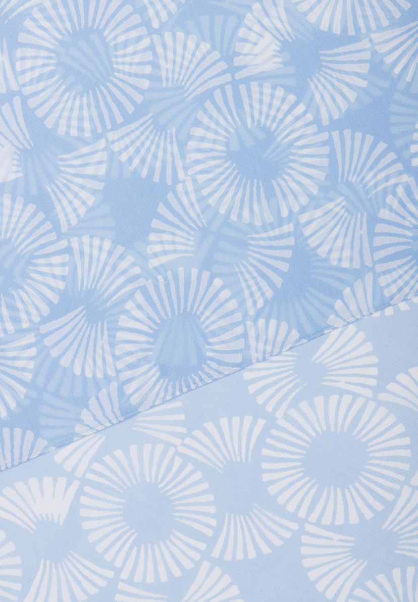 Ein hellblaues MORE & MORE Accessoire mit einem Muster aus weißen Blütenblättern um eine zentrale Scheibe. Ein hellblaues MORE & MORE Accessoire mit einem Muster aus weißen Blütenblättern um eine zentrale Scheibe.