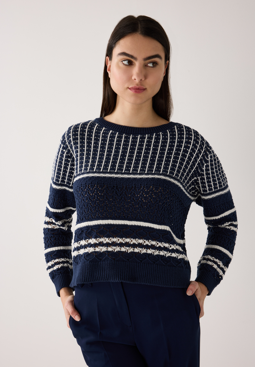 Eine Frau trägt einen dunkelblauen Strick-Pullover von MORE & MORE mit weißen Streifen. Eine Frau trägt einen dunkelblauen Strick-Pullover von MORE & MORE mit weißen Streifen.