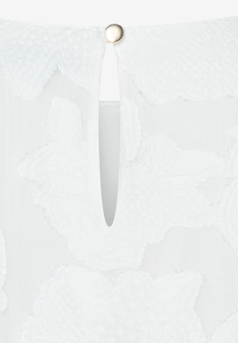 Detailaufnahme einer weißen MORE & MORE Bluse mit Knopf am Ausschnitt.