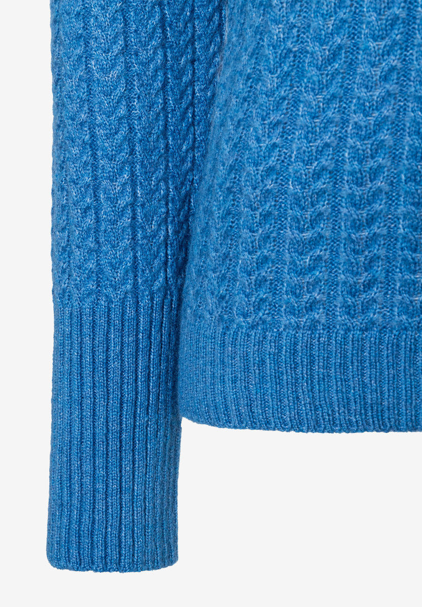 Detailansicht eines blauen MORE & MORE Strickpullovers mit Zopfmuster an Ärmel und Körper. Detailansicht eines blauen MORE & MORE Strickpullovers mit Zopfmuster an Ärmel und Körper.