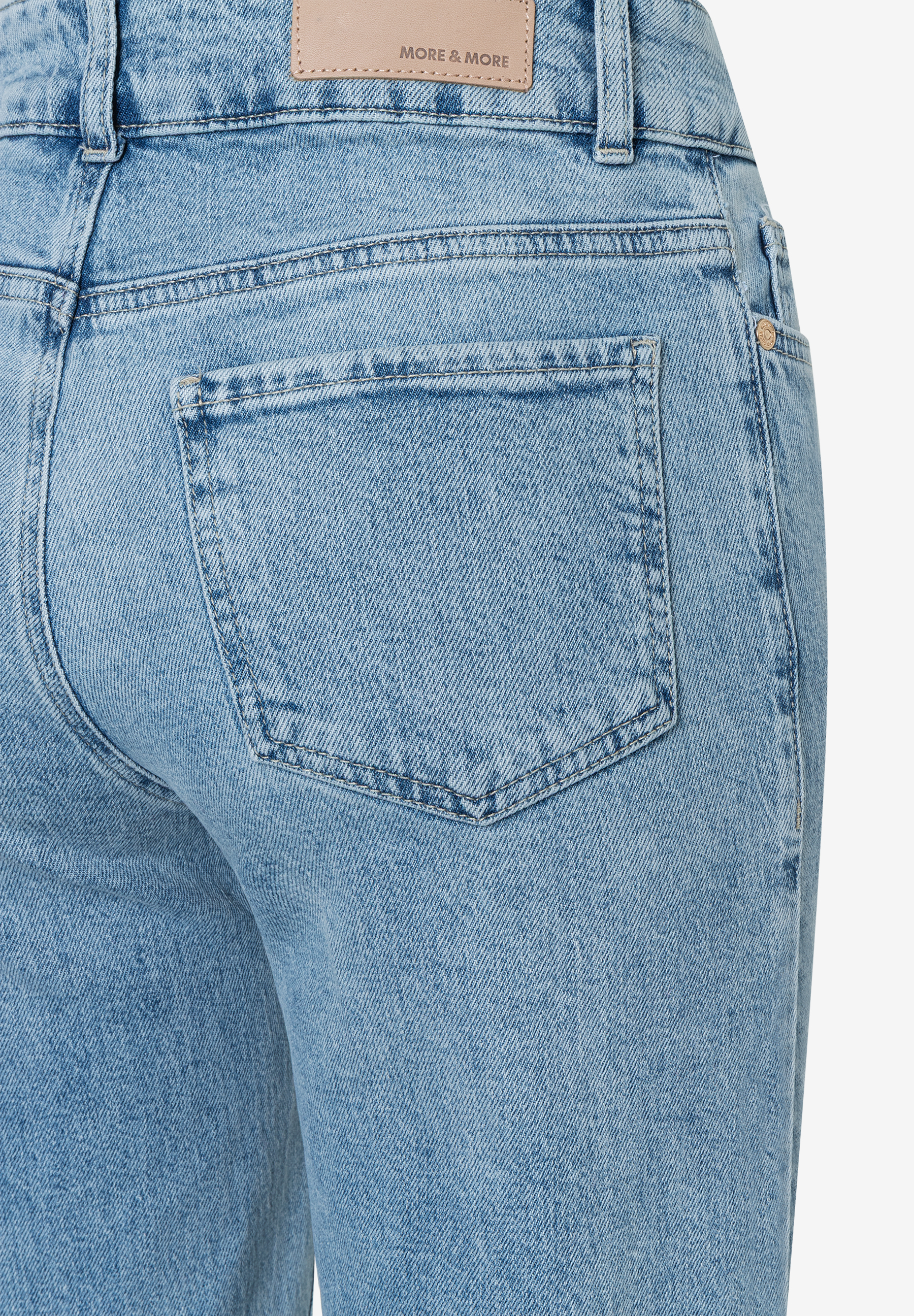Nahaufnahme der Rückseite einer MORE & MORE Jeans mit Gesäßtasche und Markenlabel. Nahaufnahme der Rückseite einer MORE & MORE Jeans mit Gesäßtasche und Markenlabel.
