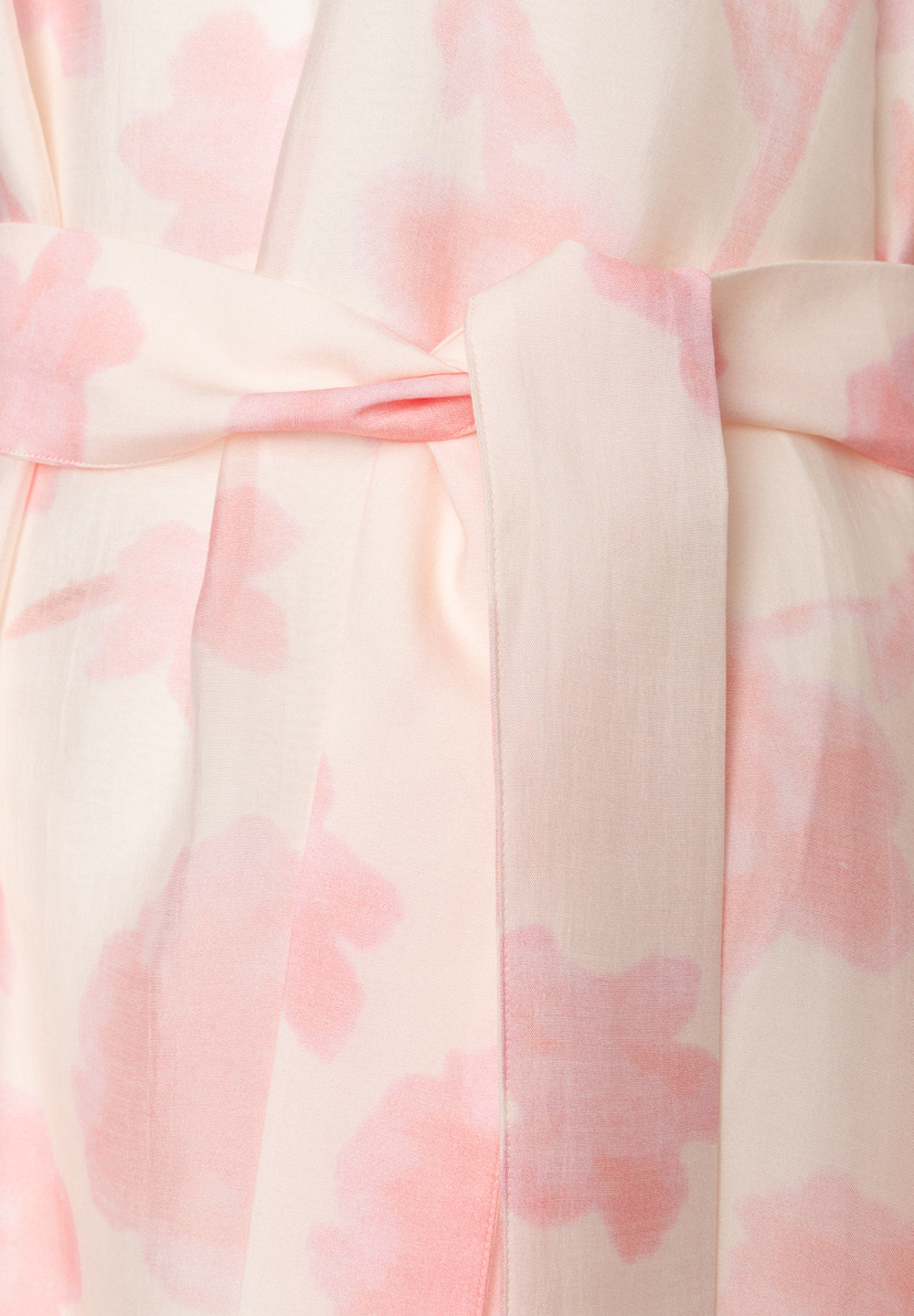 Detailansicht eines MORE & MORE Oberteils aus Chiffon mit rosa Blumenmuster und Taillenband, das für angenehmen Tragekomfort sorgt. Detailansicht eines MORE & MORE Oberteils aus Chiffon mit rosa Blumenmuster und Taillenband, das für angenehmen Tragekomfort sorgt.