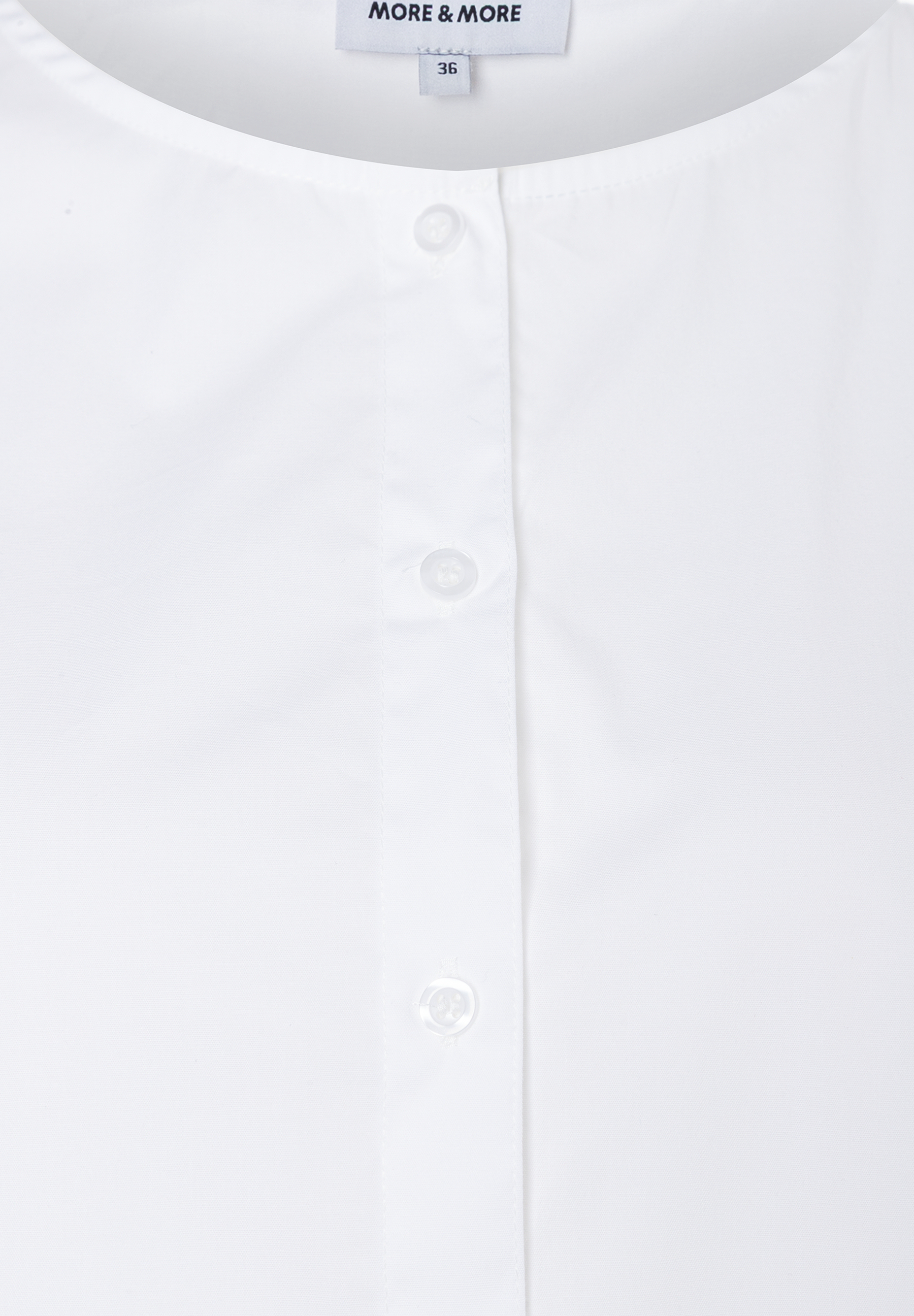 MORE & MORE weiße Bluse, Gr. 36, mit Knopfleiste und Rundhalsausschnitt. Der Markenname und die Größe sind sichtbar. MORE & MORE weiße Bluse, Gr. 36, mit Knopfleiste und Rundhalsausschnitt. Der Markenname und die Größe sind sichtbar.