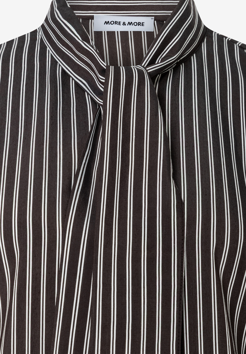MORE & MORE Bluse: Eine elegant gebundene Schleife ziert den Kragen einer schwarz-weißen gestreiften Bluse. MORE & MORE Bluse: Eine elegant gebundene Schleife ziert den Kragen einer schwarz-weißen gestreiften Bluse.