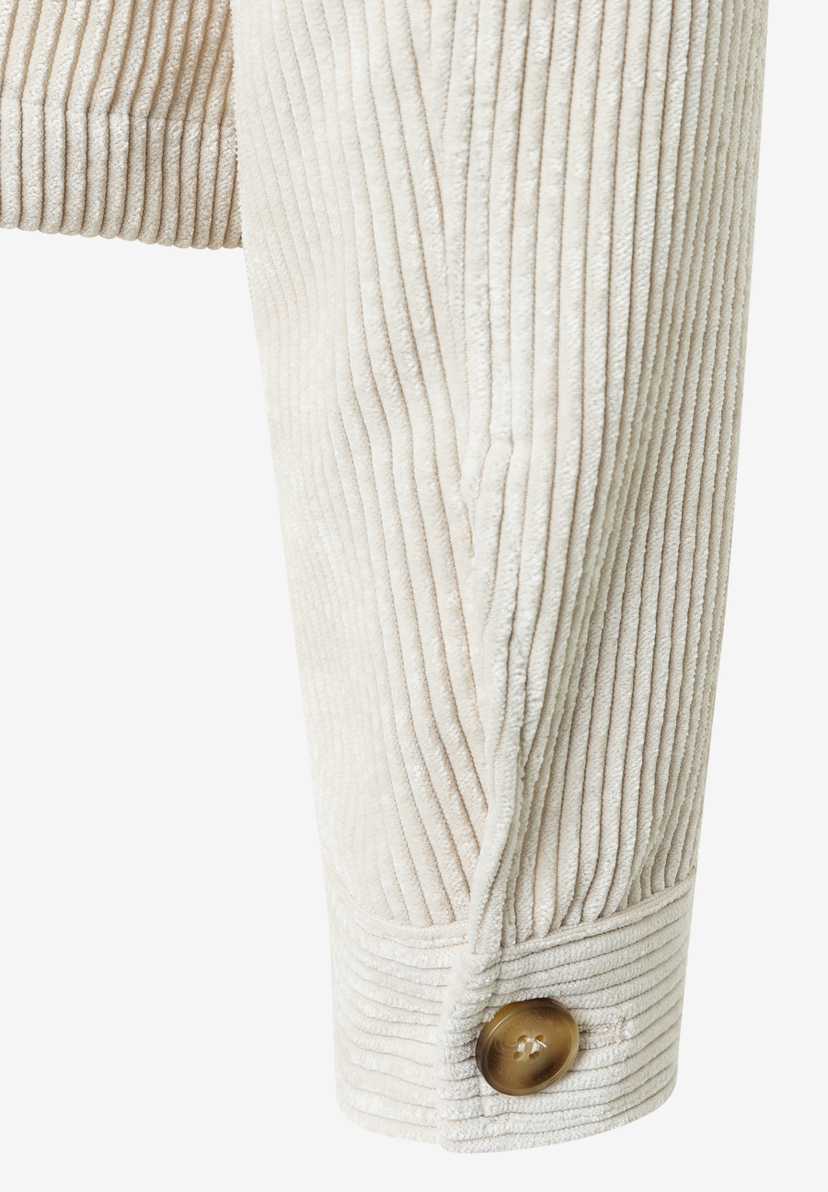 Detailaufnahme eines MORE & MORE Cord-Oberteils, das angenehm und elastisch ist, mit Knopf am Ärmel. Detailaufnahme eines MORE & MORE Cord-Oberteils, das angenehm und elastisch ist, mit Knopf am Ärmel.