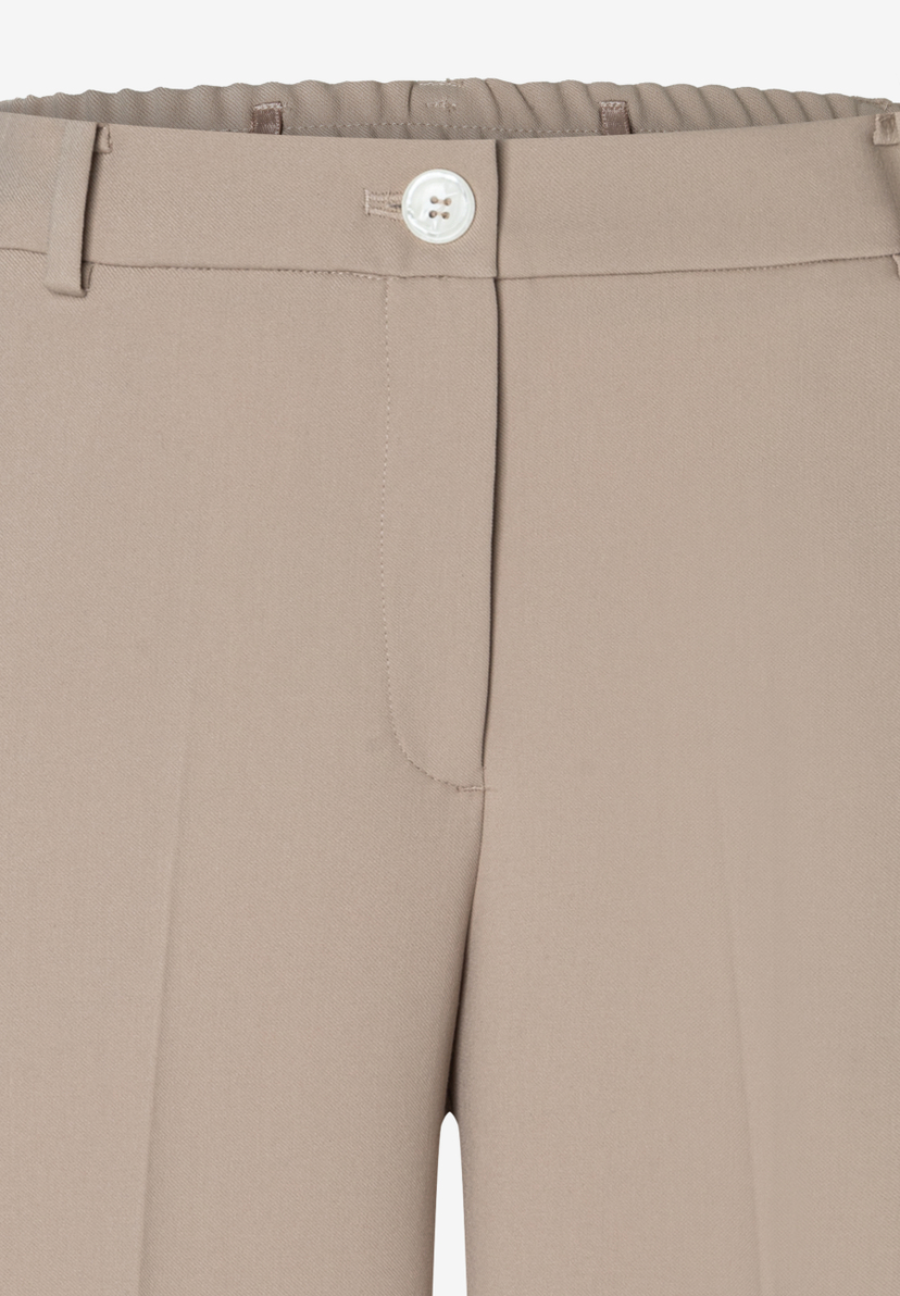 Nahaufnahme einer beigen MORE & MORE Hose mit Knopfverschluss und Webware-Material. Nahaufnahme einer beigen MORE & MORE Hose mit Knopfverschluss und Webware-Material.