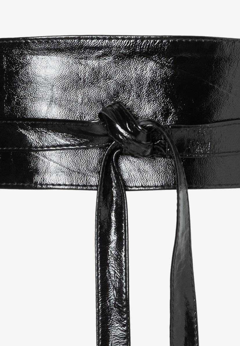 Nahaufnahme eines glänzenden, schwarzen MORE & MORE Gürtels mit Wickel-Detail vor weißem Hintergrund.