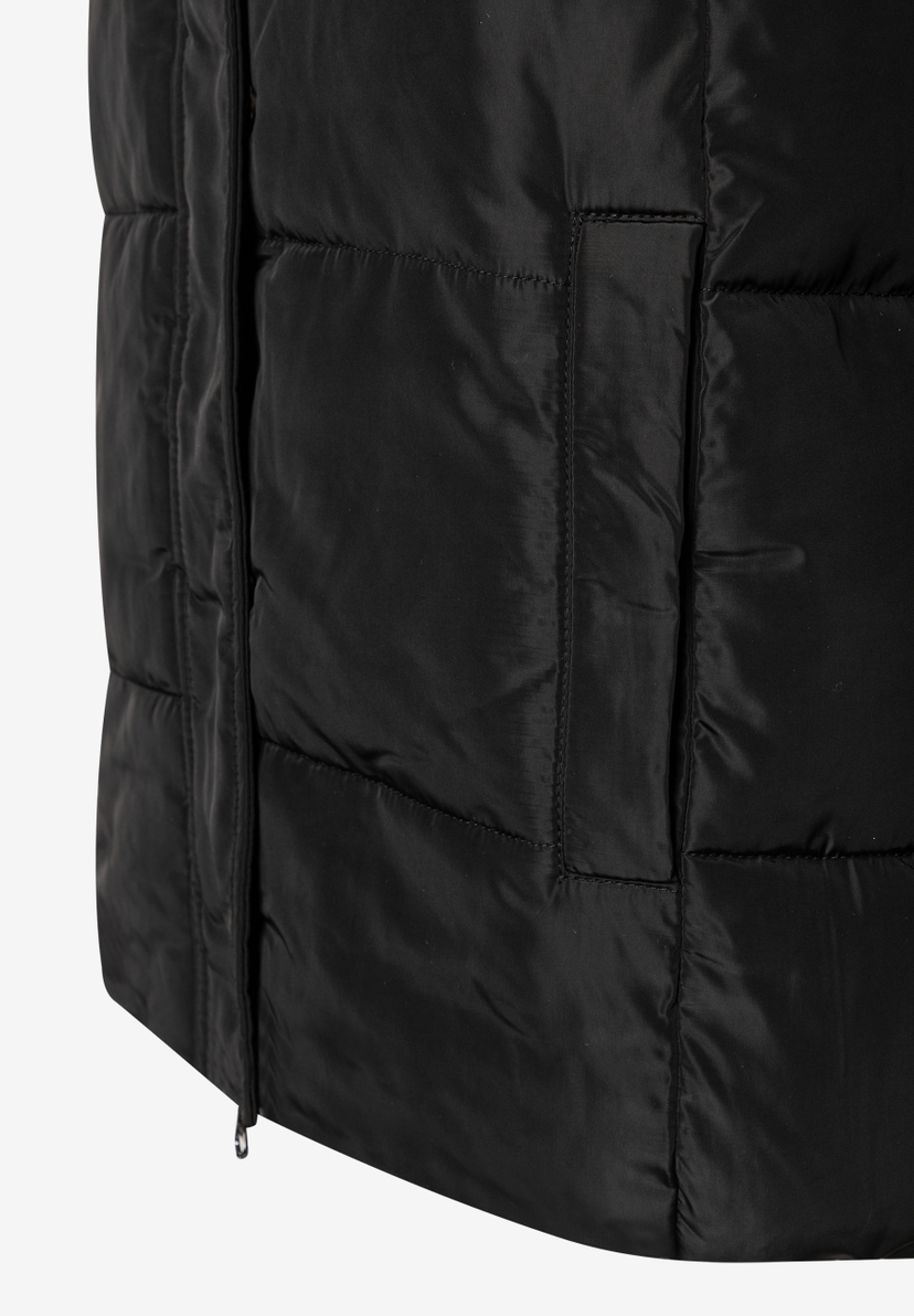 Detailaufnahme eines schwarzen MORE & MORE Oberteils mit gestepptem Design und diskretem Reißverschluss. Detailaufnahme eines schwarzen MORE & MORE Oberteils mit gestepptem Design und diskretem Reißverschluss.