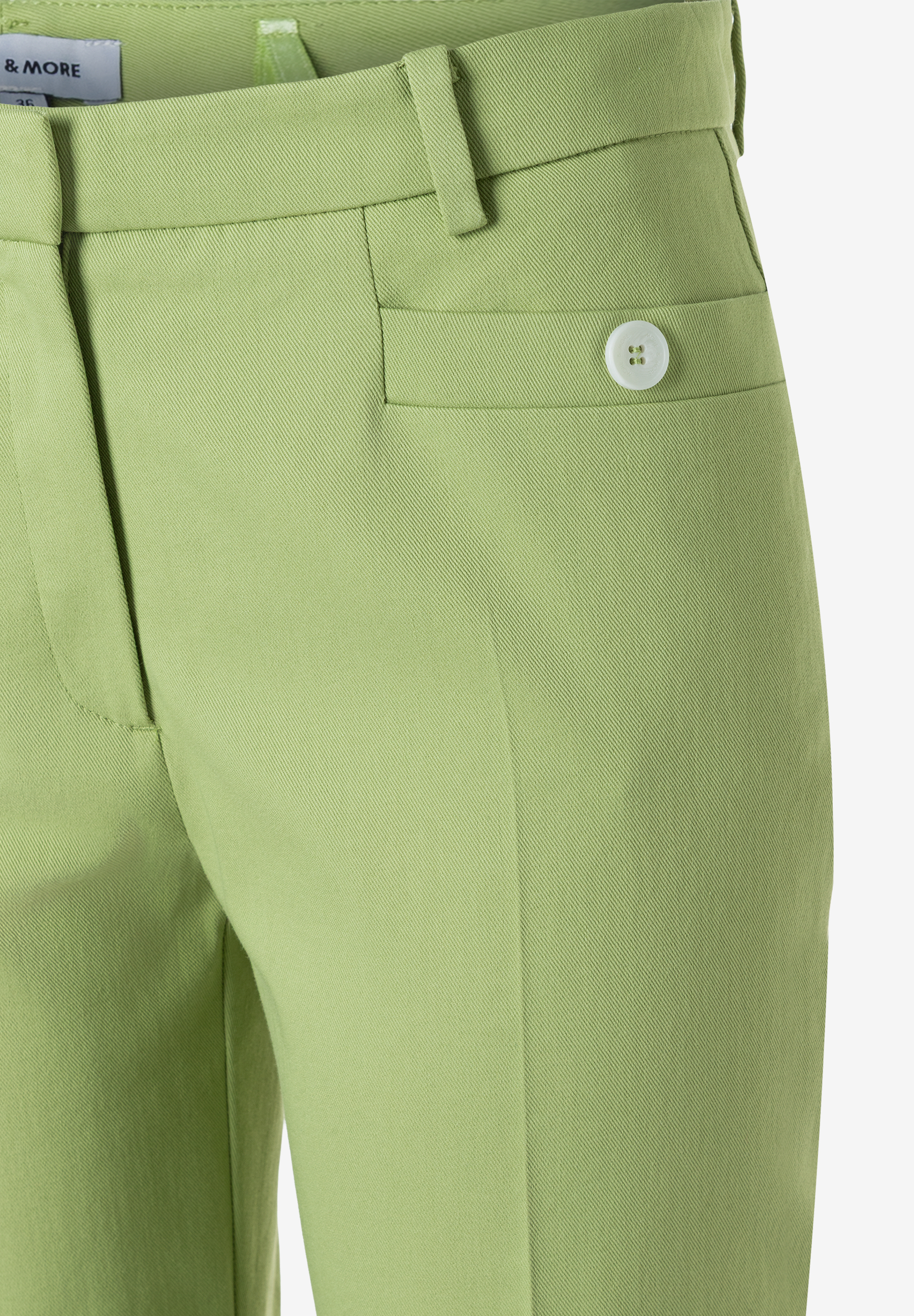 Nahaufnahme einer MORE & MORE Hose, Gabardine aus Baumwollmischung, in hellem Grün. Knopfdetail an der Tasche. Nahaufnahme einer MORE & MORE Hose, Gabardine aus Baumwollmischung, in hellem Grün. Knopfdetail an der Tasche.