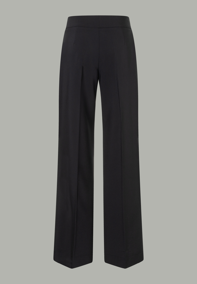 Eine schwarze MORE & MORE Hose mit weitem Bein auf hellgrauem Grund. Eine schwarze MORE & MORE Hose mit weitem Bein auf hellgrauem Grund.