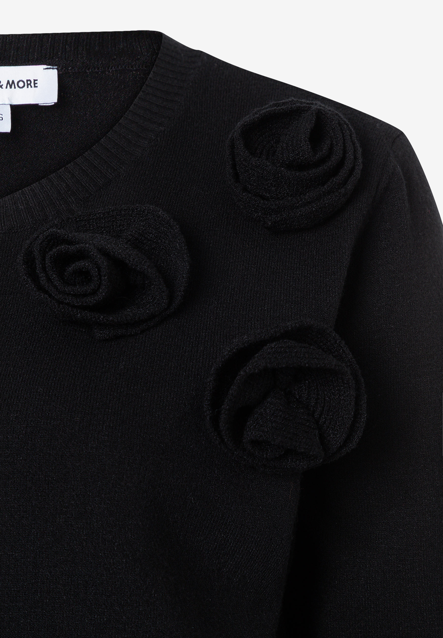 MORE & MORE schwarzer Pullover/Strickware mit 3D-Rosenapplikationen und sichtbarem Markenetikett am Ausschnitt. MORE & MORE schwarzer Pullover/Strickware mit 3D-Rosenapplikationen und sichtbarem Markenetikett am Ausschnitt.