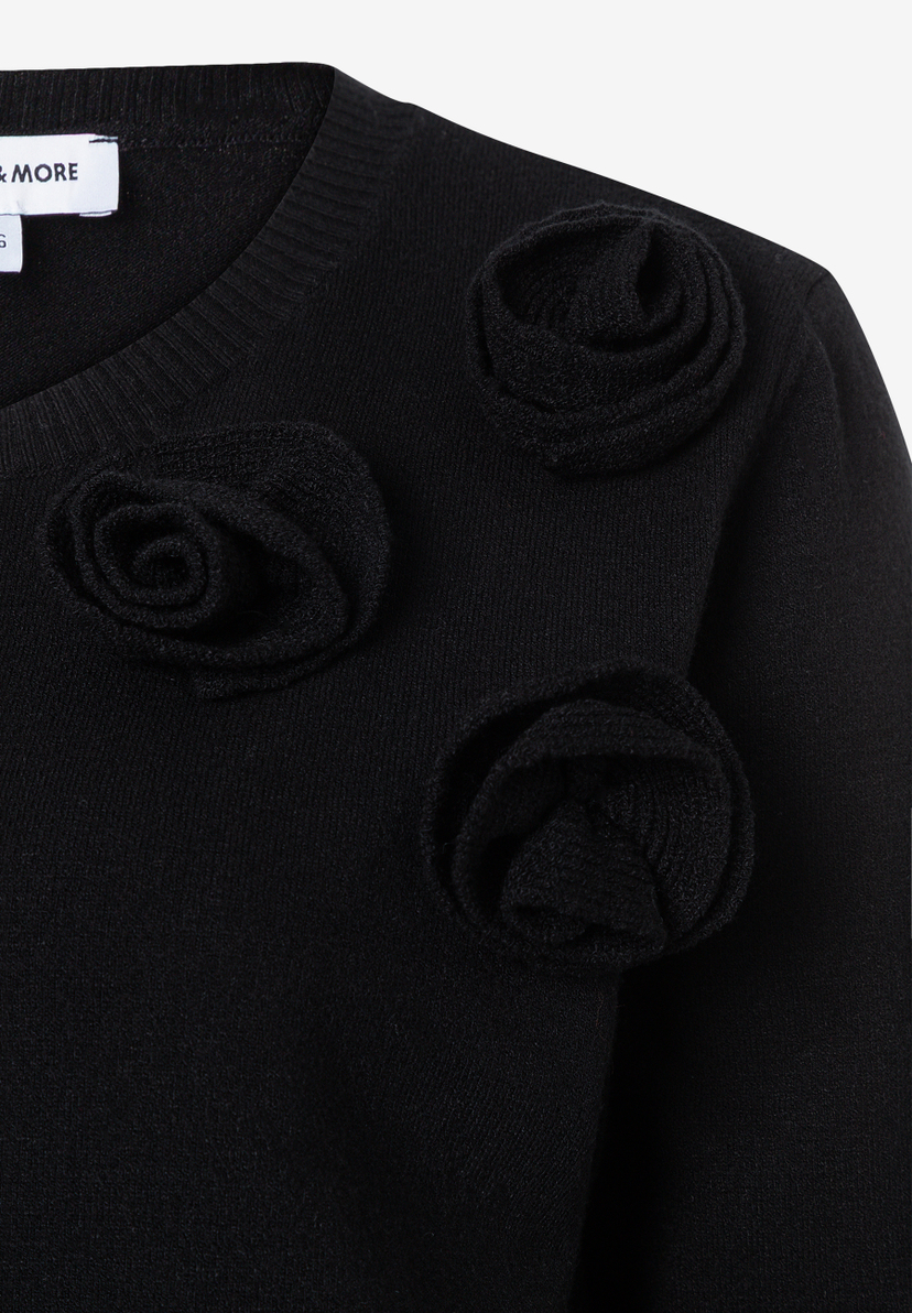 MORE & MORE schwarzer Pullover/Strickware mit 3D-Rosenapplikationen und sichtbarem Markenetikett am Ausschnitt. MORE & MORE schwarzer Pullover/Strickware mit 3D-Rosenapplikationen und sichtbarem Markenetikett am Ausschnitt.