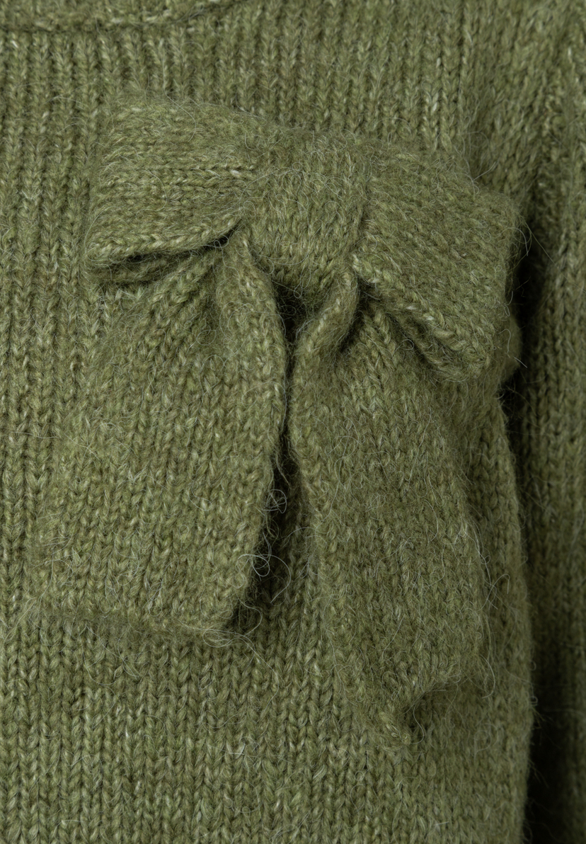 Nahaufnahme eines grünen MORE & MORE Strick-Pullovers mit einer dekorativen Schleife. Nahaufnahme eines grünen MORE & MORE Strick-Pullovers mit einer dekorativen Schleife.