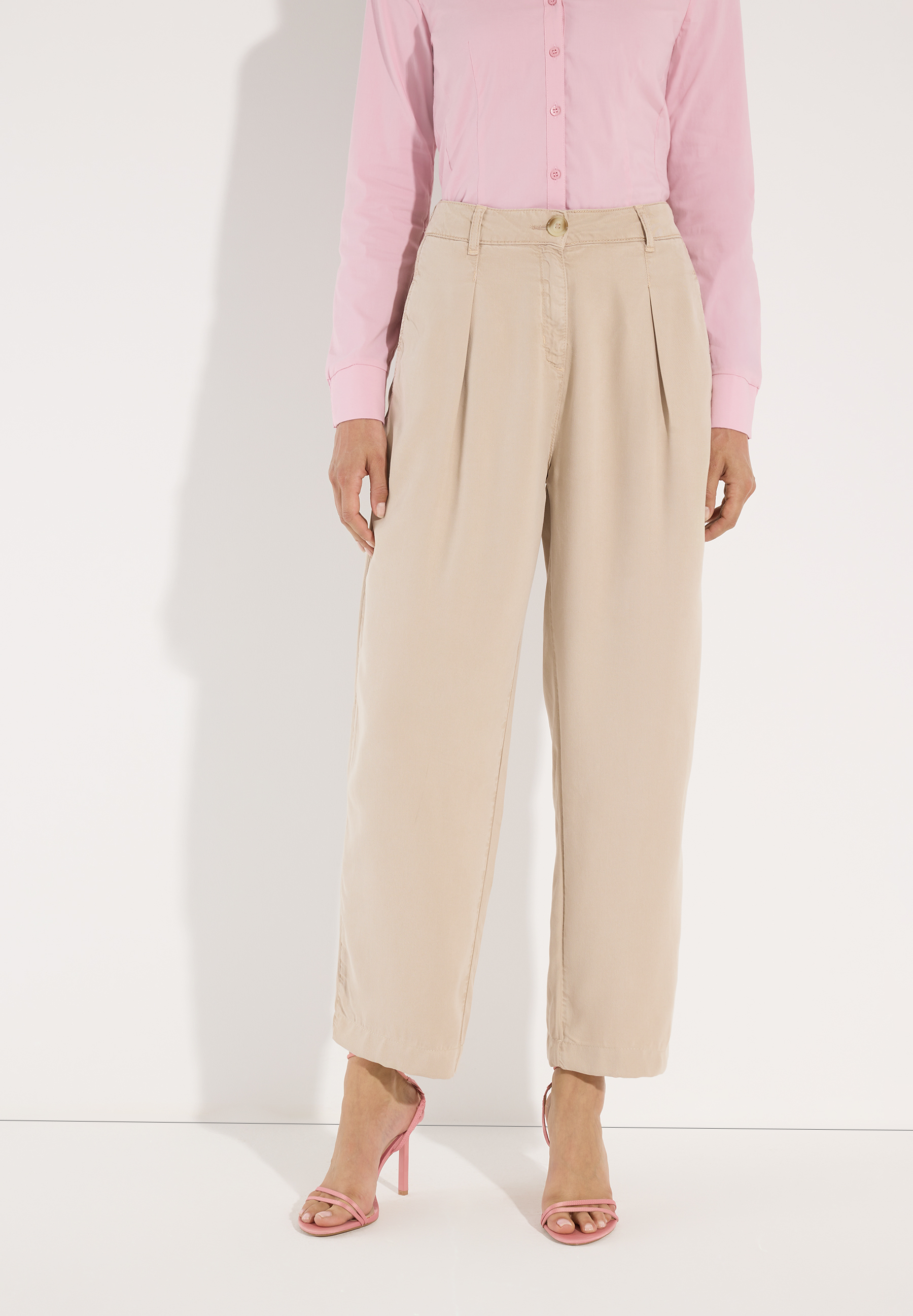 MORE & MORE Damen-Hose aus beigem Webstoff, kombiniert mit pinker Bluse und pinken High Heels, für angenehmen Tragekomfort.