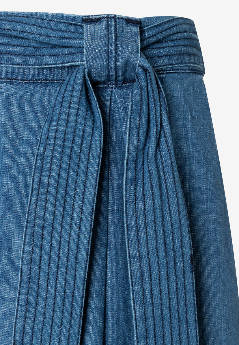 Detailaufnahme eines MORE & MORE Jeansrockes mit Bindegürtel. Das Material ist leicht und hautfreundlich.