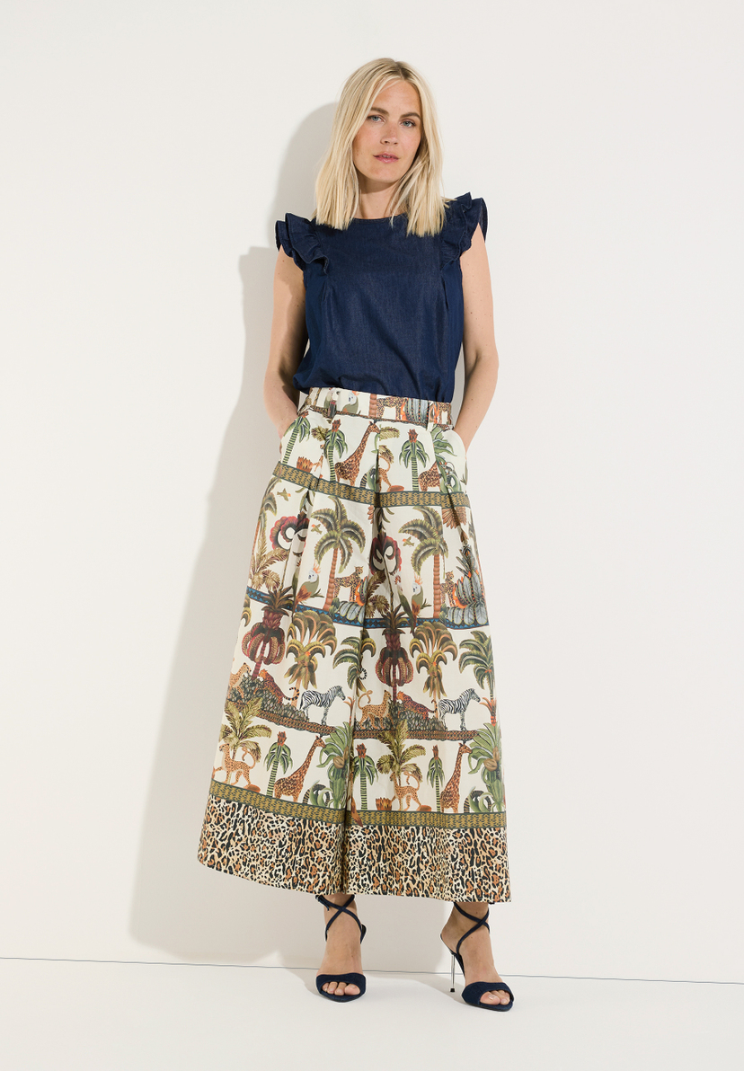 MORE & MORE Jeans: Blonde Frau trägt lässige Jeans mit Dschungel-Print, Leopardenmuster und High Heels. MORE & MORE Jeans: Blonde Frau trägt lässige Jeans mit Dschungel-Print, Leopardenmuster und High Heels.