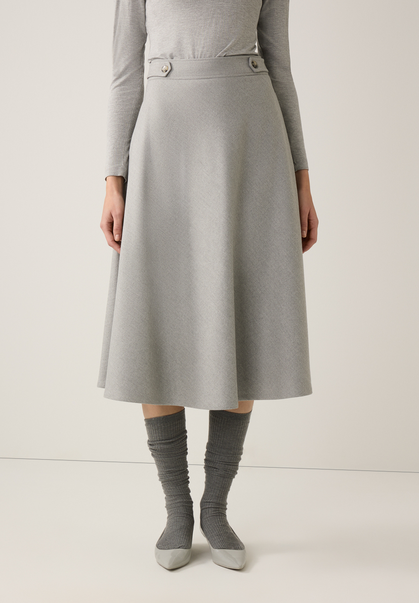 Ein grauer MORE & MORE Rock in A-Linie mit Knöpfen am Bund, kombiniert mit passenden Strümpfen und Schuhen. Ein grauer MORE & MORE Rock in A-Linie mit Knöpfen am Bund, kombiniert mit passenden Strümpfen und Schuhen.