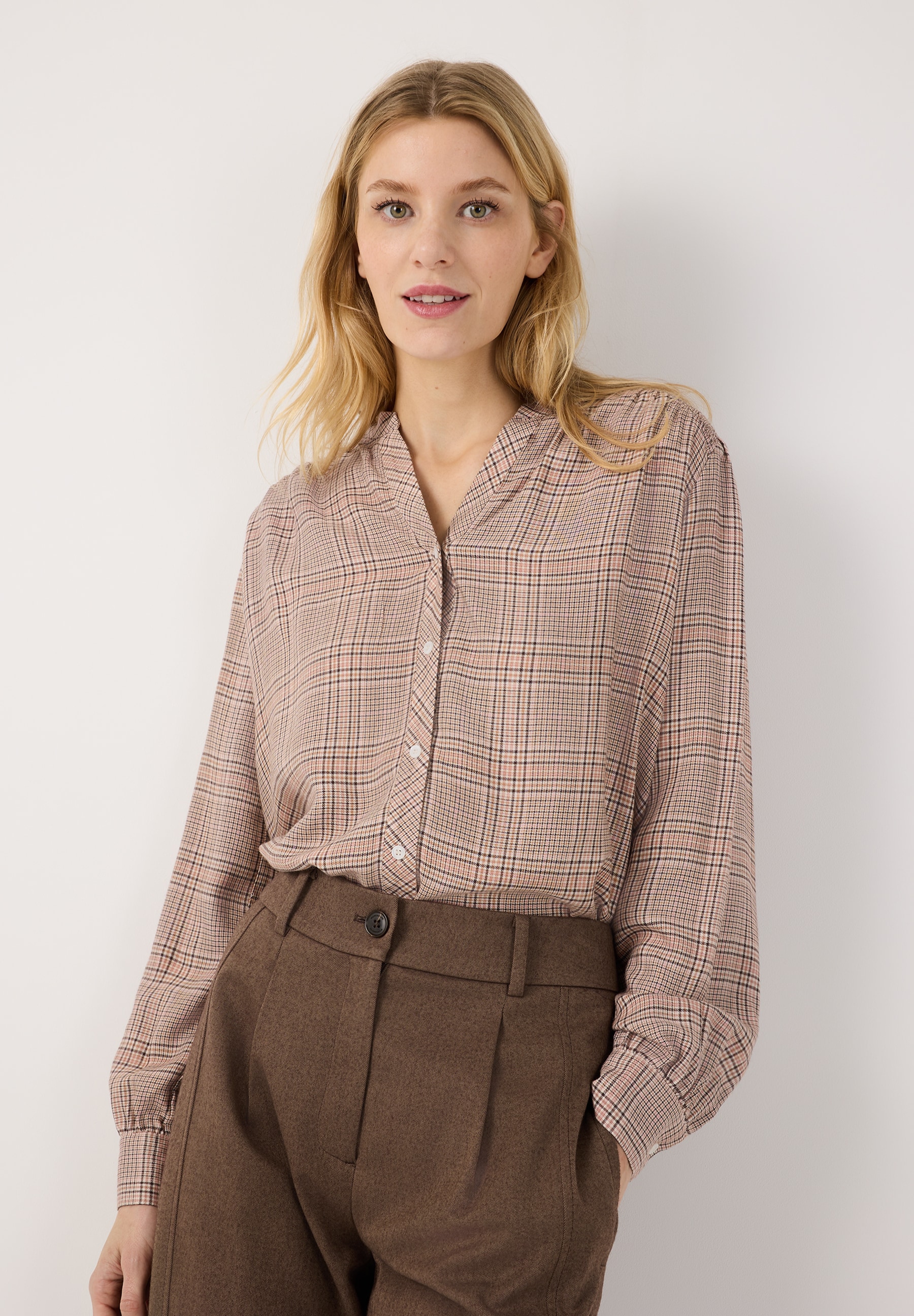 MORE & MORE Bluse: Eine blonde Frau mit Mittelscheitel, grünen Augen und rosa Lippen trägt eine beigefarbene Bluse. MORE & MORE Bluse: Eine blonde Frau mit Mittelscheitel, grünen Augen und rosa Lippen trägt eine beigefarbene Bluse.