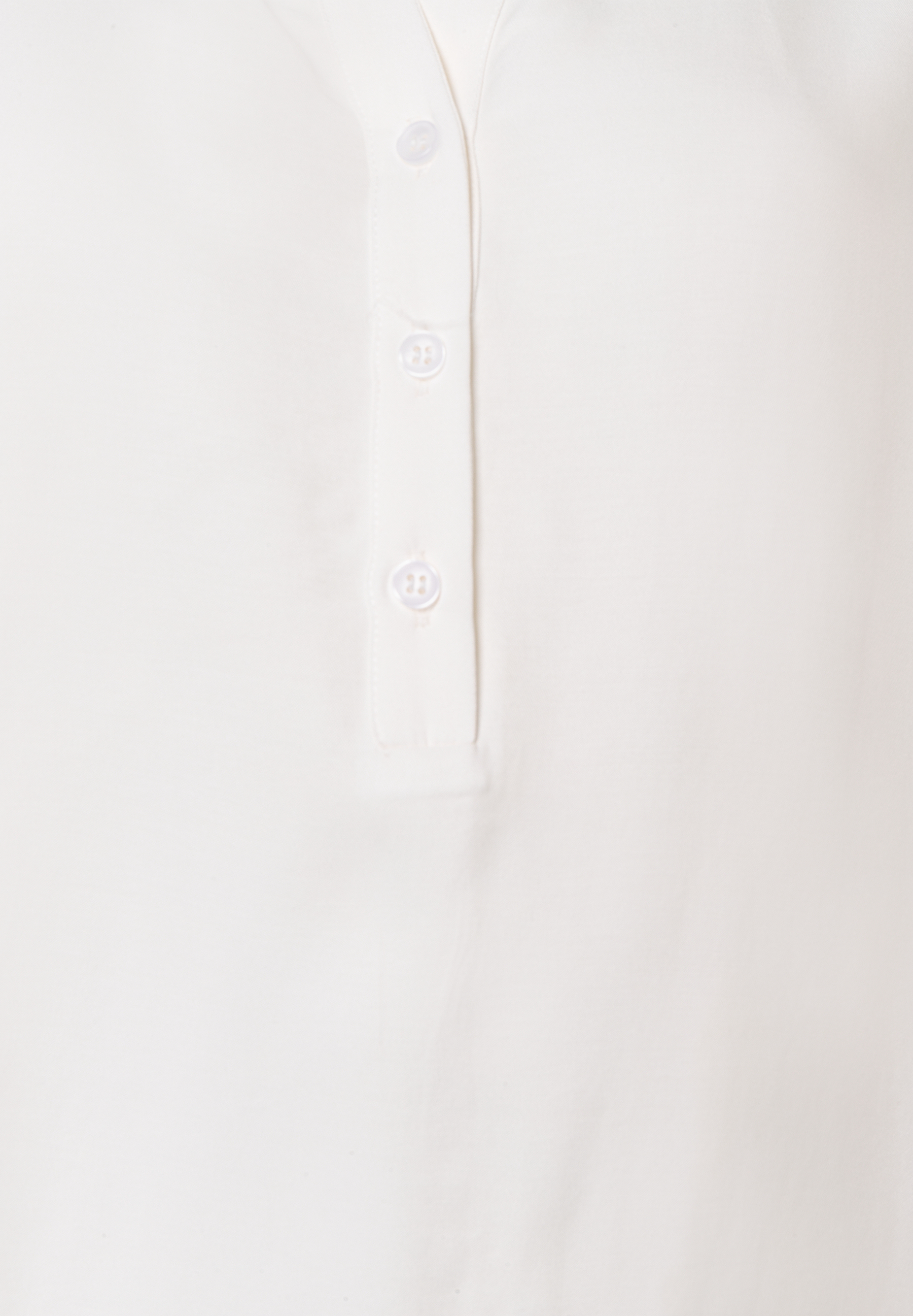 Nahaufnahme einer weißen MORE & MORE Bluse aus fließender Viskose mit drei Knöpfen. Nahaufnahme einer weißen MORE & MORE Bluse aus fließender Viskose mit drei Knöpfen.