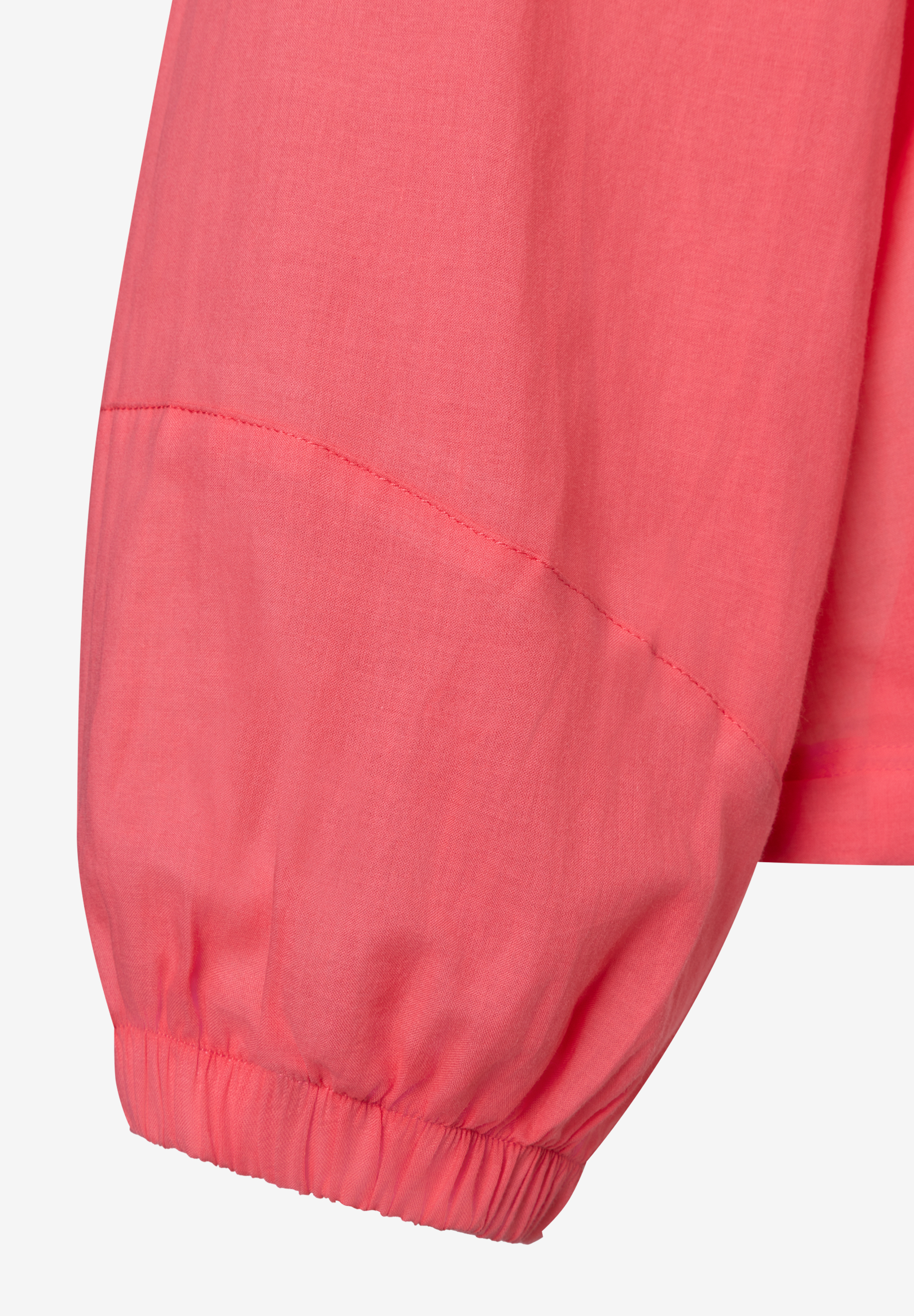 Detailaufnahme des Ärmels einer lachsfarbenen Bluse von MORE & MORE mit Gummizug am Handgelenk.