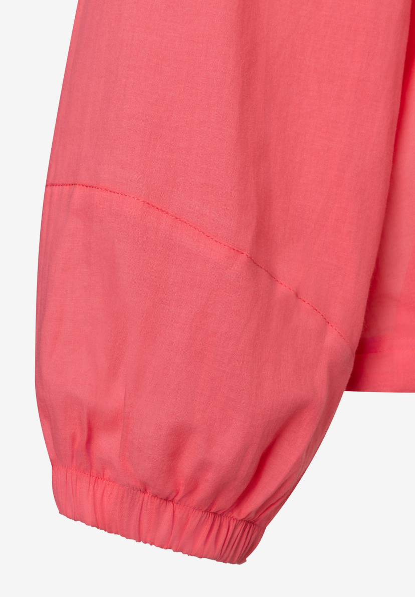 Detailaufnahme des Ärmels einer lachsfarbenen Bluse von MORE & MORE mit Gummizug am Handgelenk.